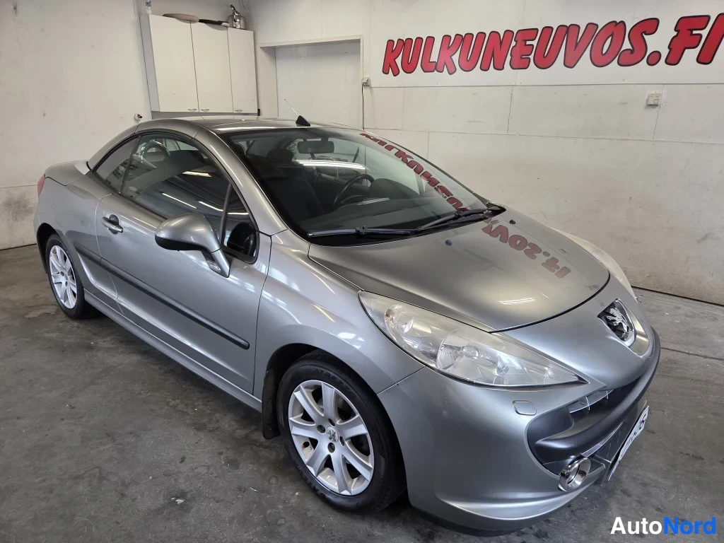 Etuviisto, nokka oikealle: Peugeot 207CC avomalli kylki ja keula kuvan oikealla, harmaa runko.