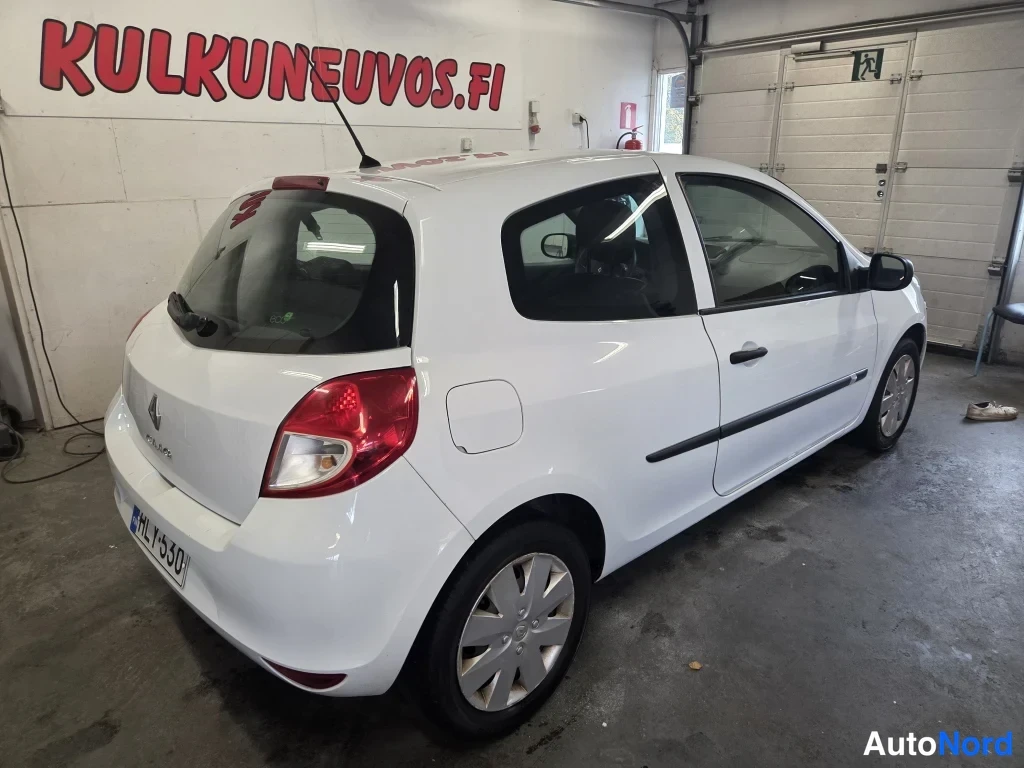 Takaviisto: Valkoinen Renault Clio -henkilöauto takavartalo-otteesta vasemmalta sisätiloissa.