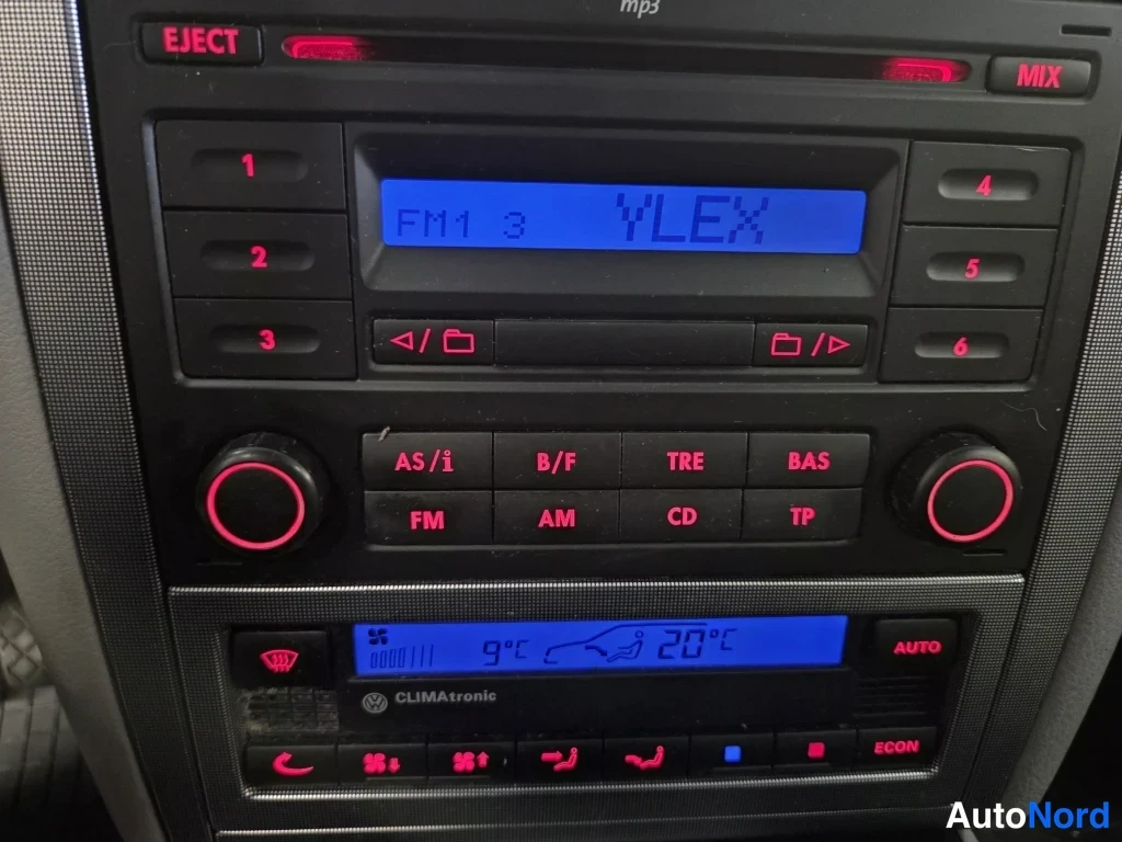 Muu: Auton kojelaudan keskiosa: radiok setä CD-soitin, jonka näytössä lukee FM1 3 YLEX, ja alla Climatronic -automatisoitu ilmastointipaneeli, jossa näkyy 9 °C ulkol