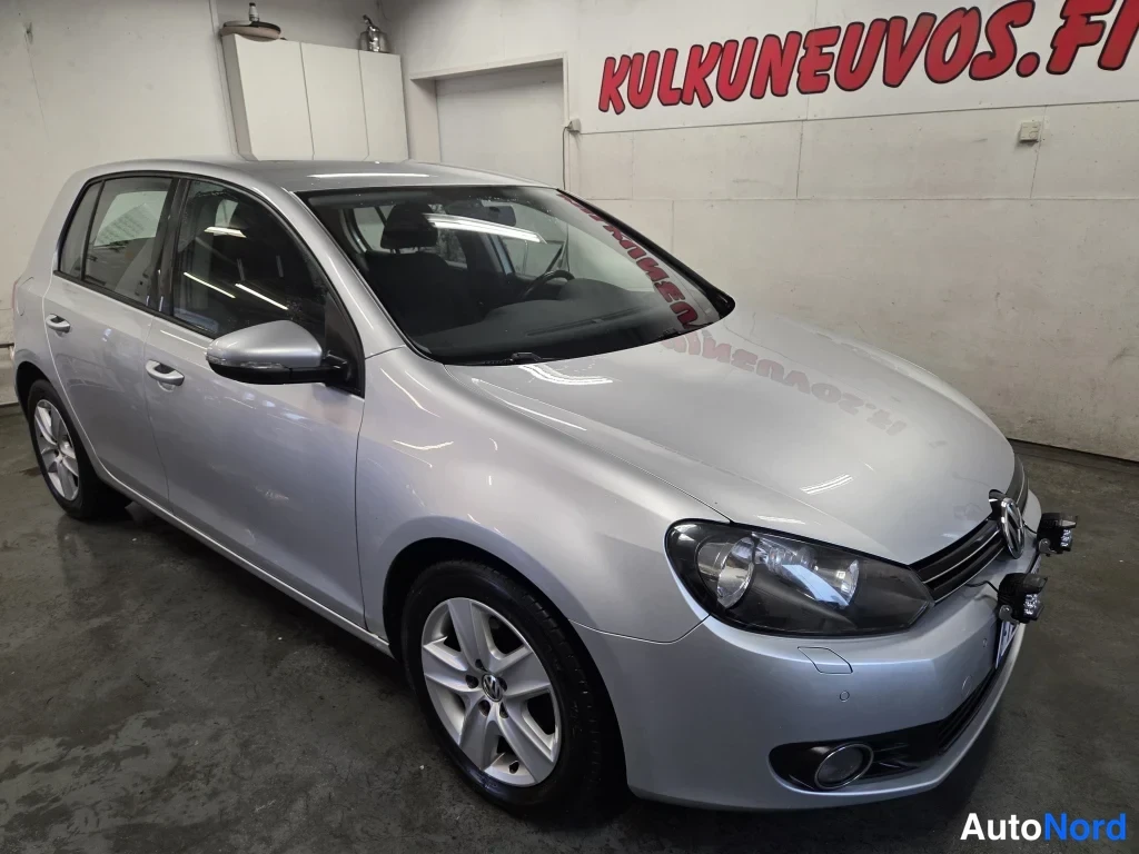 Etuviisto, nokka oikealle: Hopeanharmaa viistoperä Volkswagen Golf sisätiloissa, etukulmasta oikealta.