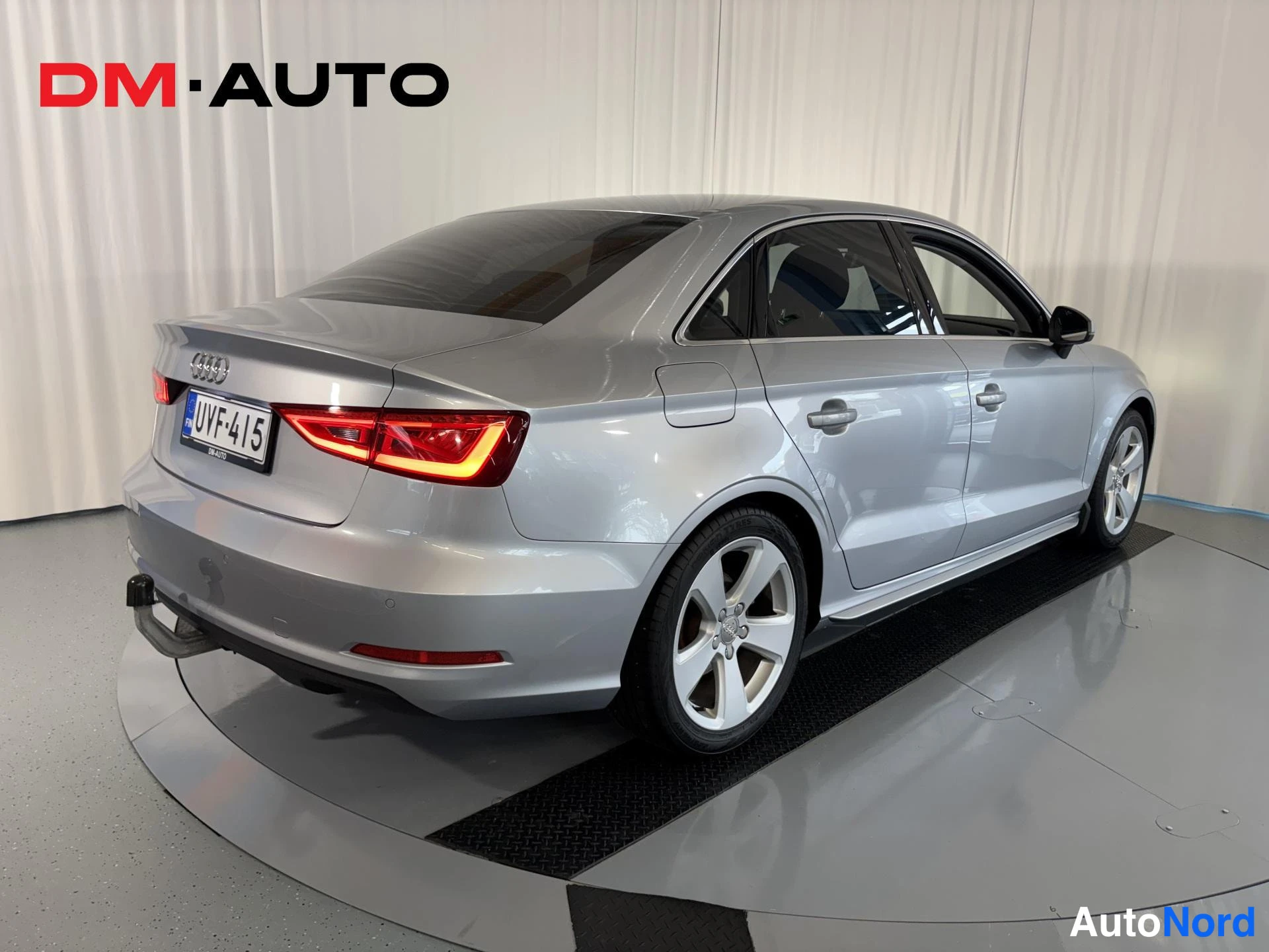 Takaviisto: Audi A3 -sedanin takakulma vasemmalta; hopeaa runkoa, punaiset takavalot, rekisteritunnus ja valkometallivanteet.