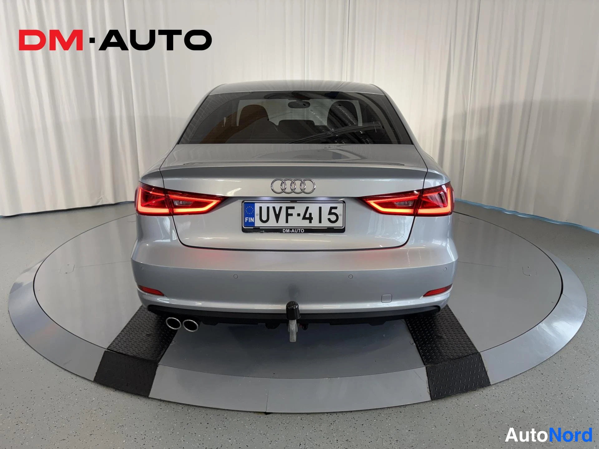 Takaa: Audi A3 -sedanin suora takanäkymä; hopea takaosa, punaiset takavalot, rekisteritunnus, kaksipäinen pakoputki ja vetokoukku.