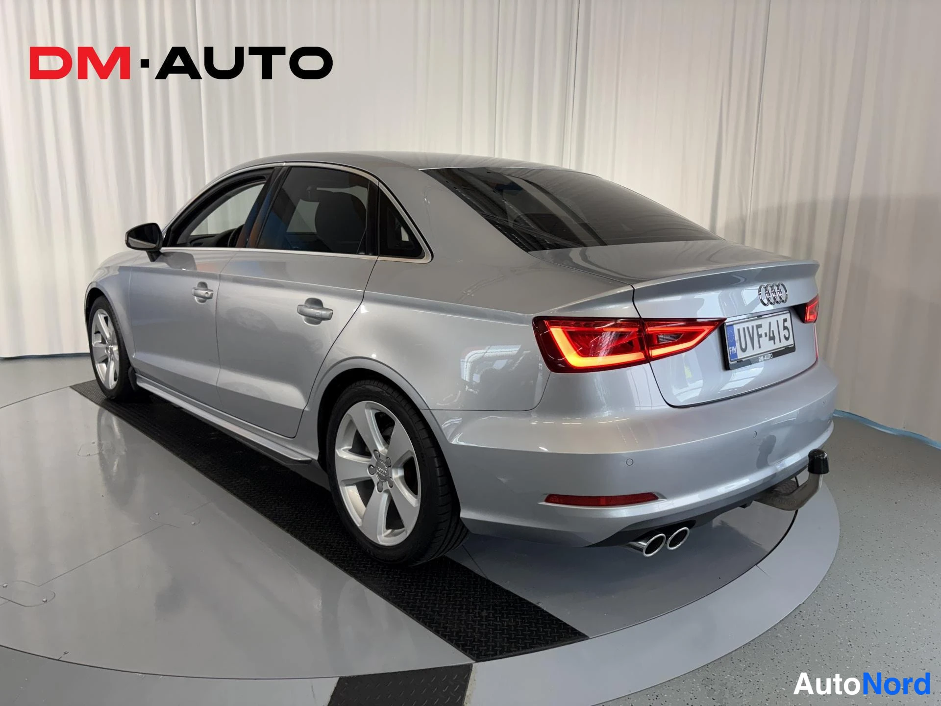 Takaviisto: Audi A3 -sedanin takakulma oikealta; hopeaa korirakennetta, punaiset takavalot, rekisteritunnus, kaksipäinen pakoputki ja vetokoukku.