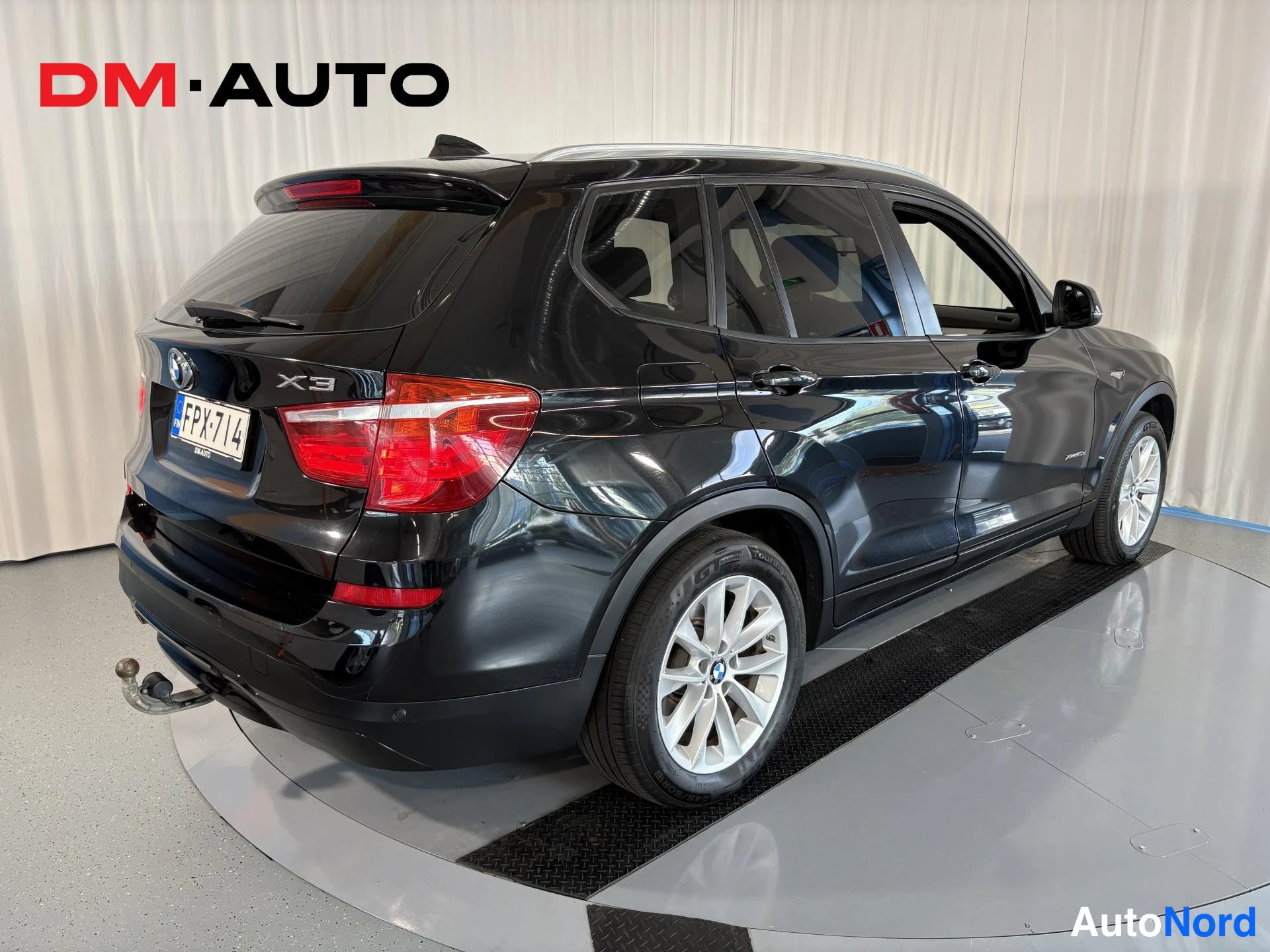 Takaviisto: Mustan BMW X3:n takakolmannesvasen, rekisterikilpi, katkaisinetroit takana.