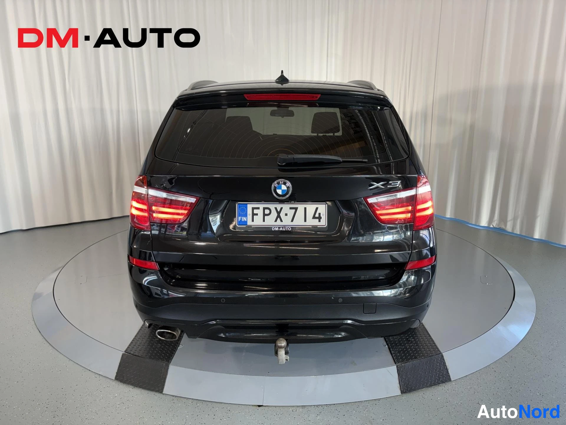 Takaa: Mustan BMW X3:n takaosa, rekisterikilpi, BMW-logo ja X3-tunnus puskurissa.