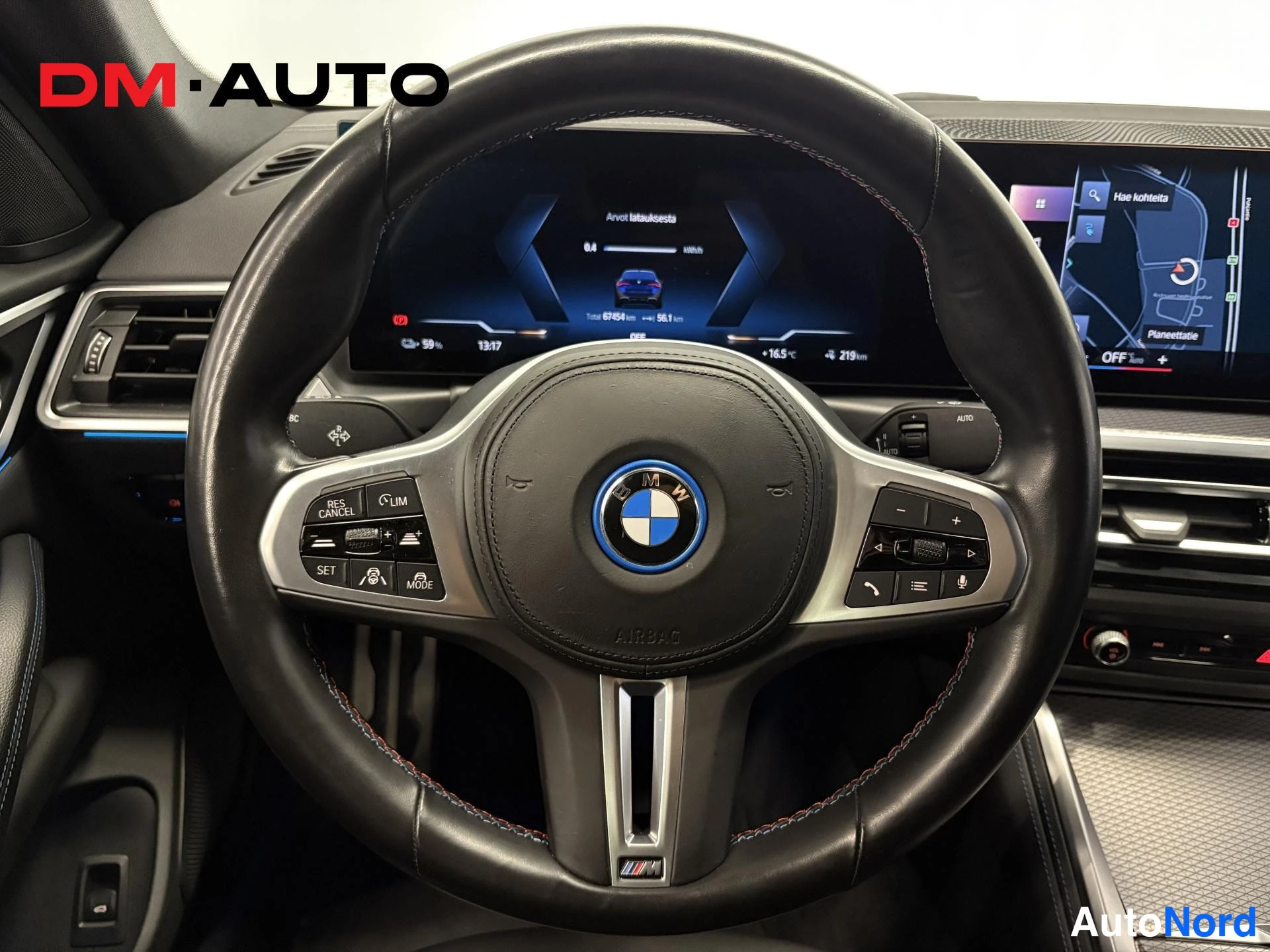 Muu: BMW-ohjauspyörä lähikuvassa, taustalla kurkistusnäyttö, jolla näkyy 'Arvot talukuesta', kellonaika 13:17 ja ulkolämpötila +16,5 °C.