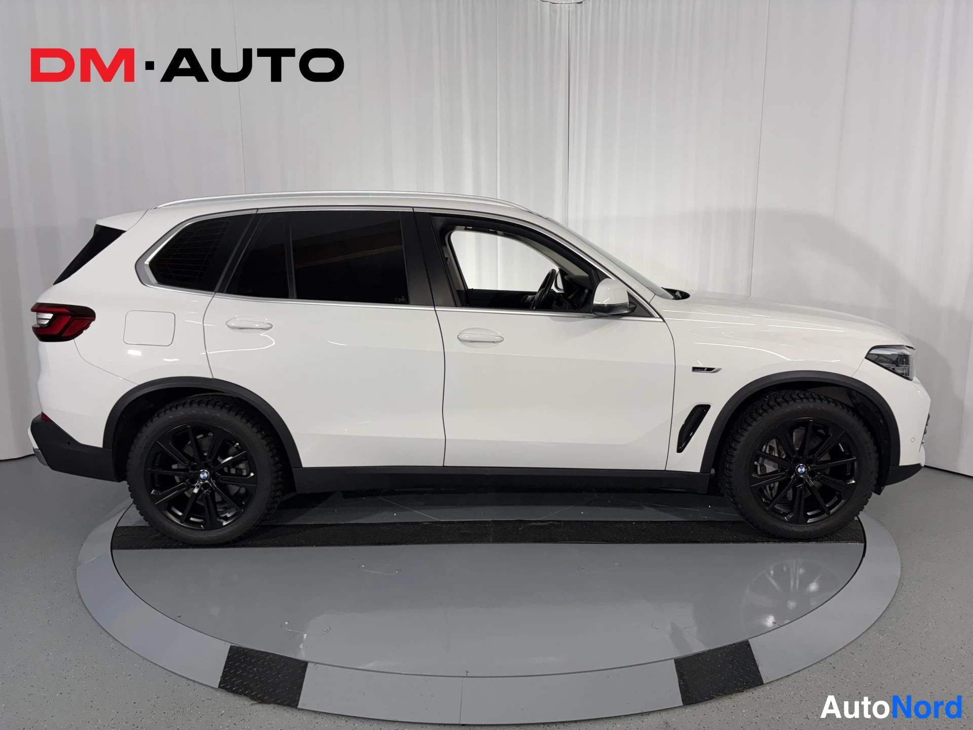 Sivulta: BMW X5, valkoinen, sivunäkymä vasemmalta; tummat ikkunat ja mustat vanteet näkyvät.