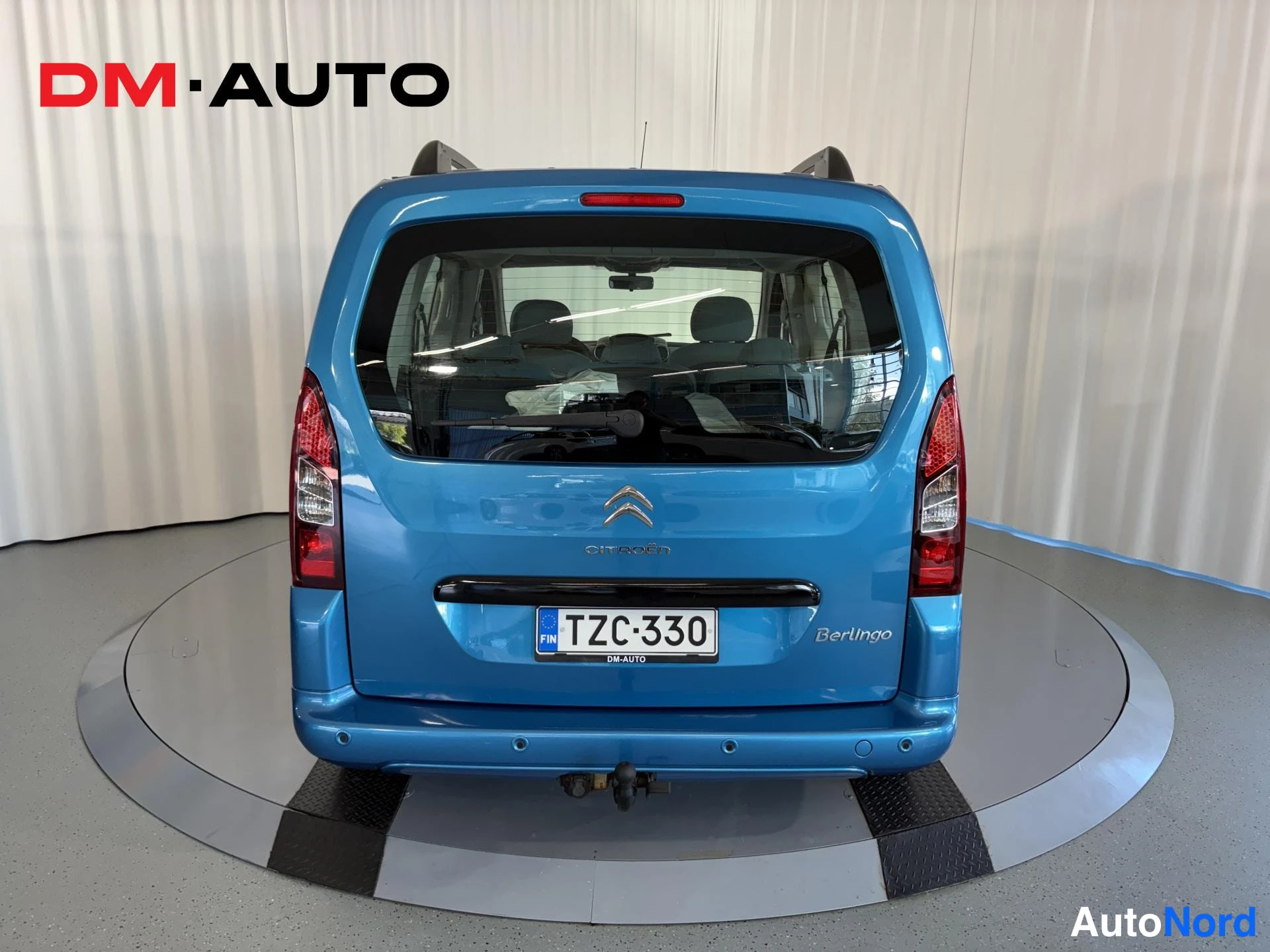 Takaa: Sininen Citroën Berlingo suoraan takaa, rekisteritunnus, vetokoukku näkyvissä.