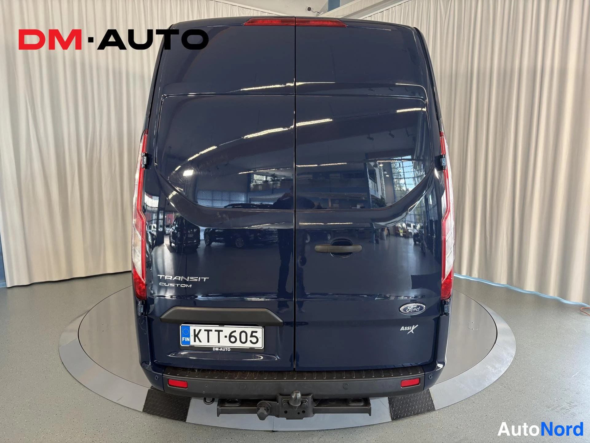 Takaa: Pakettiauto suoraan takaa kuvattuna hallissa.