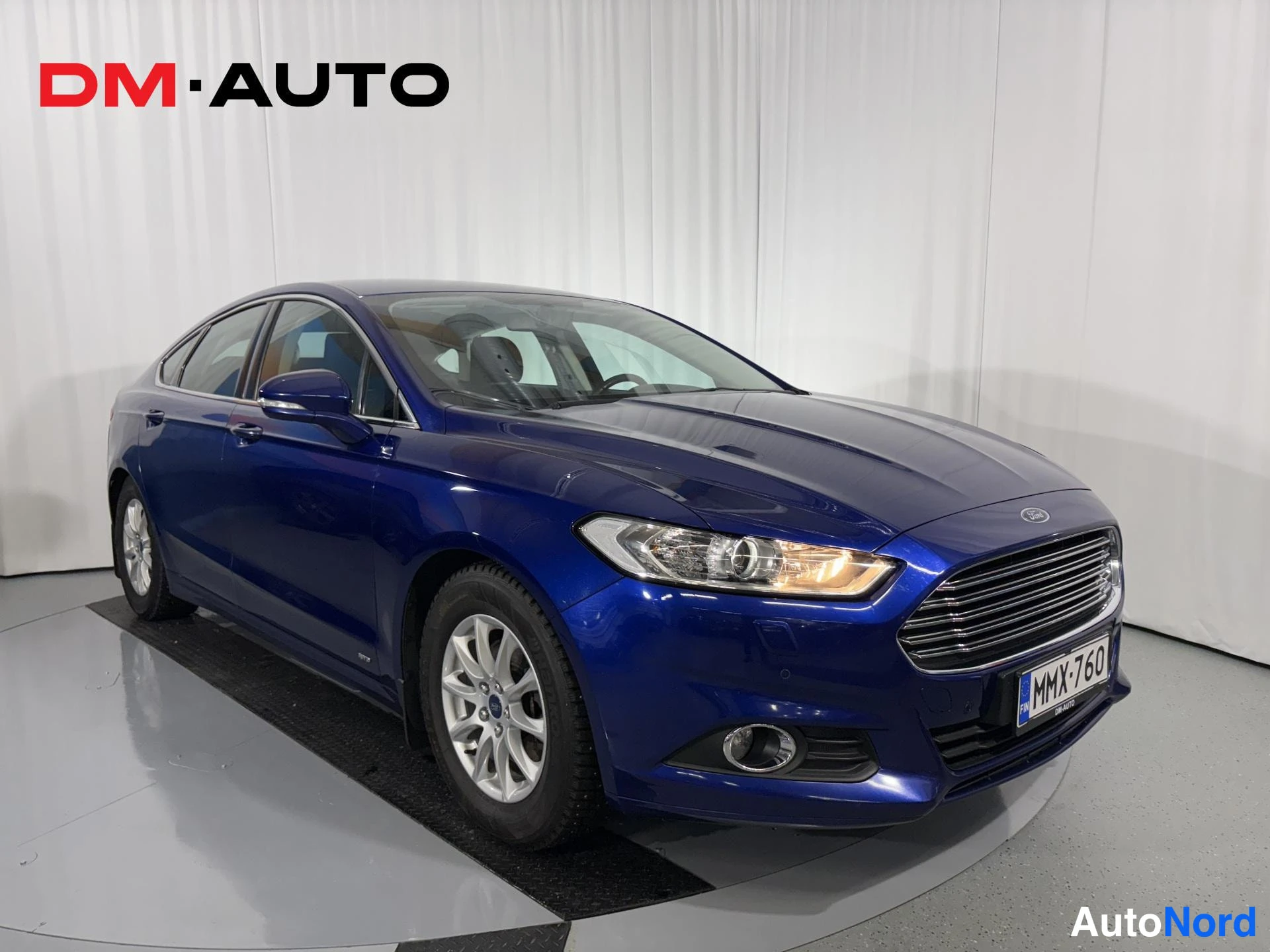 Etuviisto, nokka oikealle: Sininen Ford Mondeo edestä oikealta kuvattuna, rekisterikilpi.