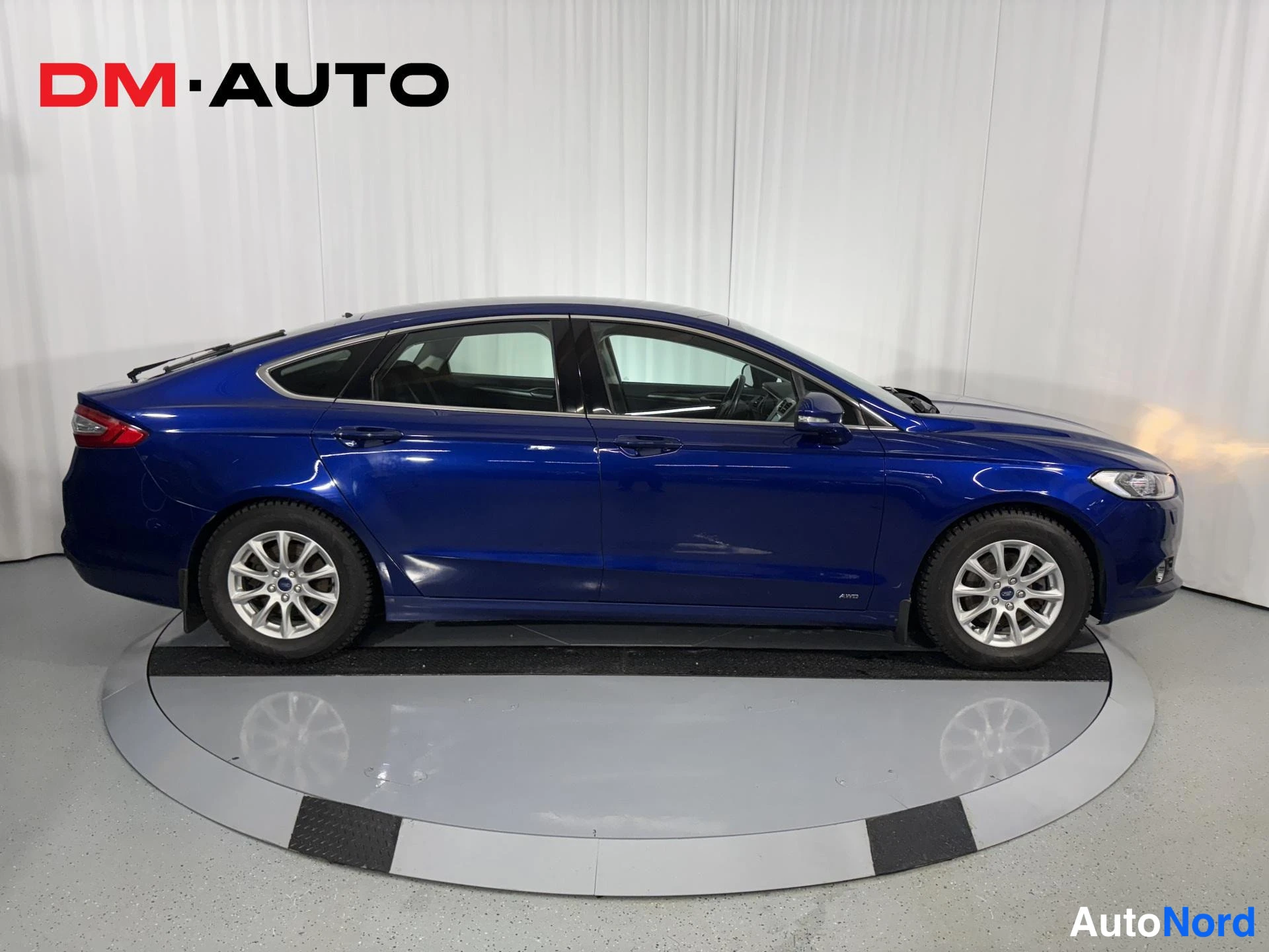 Sivulta: Sininen Ford Mondeo sivulta vasemmalta kuvattuna.