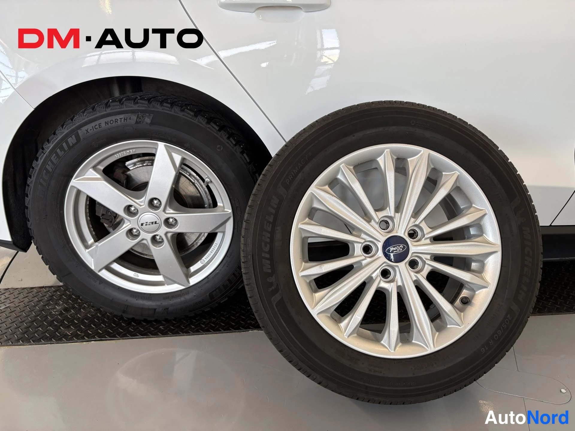 Sivulta: Renkaiden ja vanteiden yksityiskohta: Michelin X-Ice North 4 -kitkarengas autossa ja erillinen Ford-alkuinen aluvanne