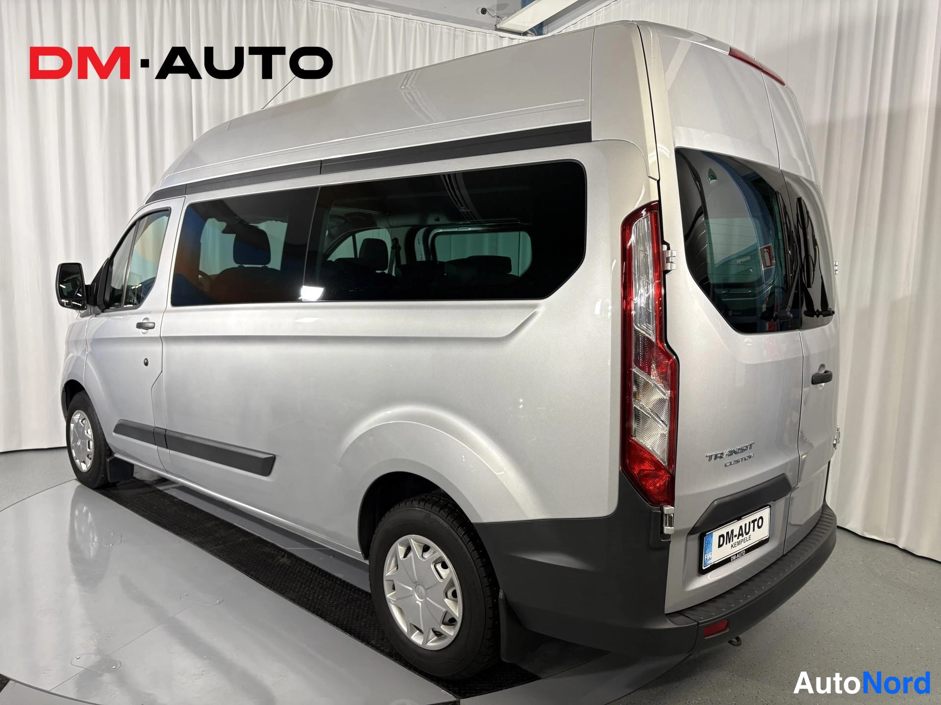 Takaviisto: Ford Transit Custom -pakettiauto takaosasta viistosti, hopeinen; takaosa ja kylki näkyvissä.