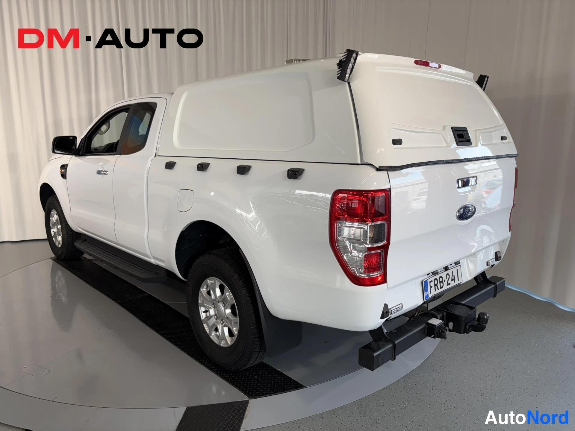 Takaviisto: Ford Ranger takaa viistosti vasemmalta; valkoinen kori, peitekansi lavalla, Ford-merkki takaluukussa ja rekisteri.