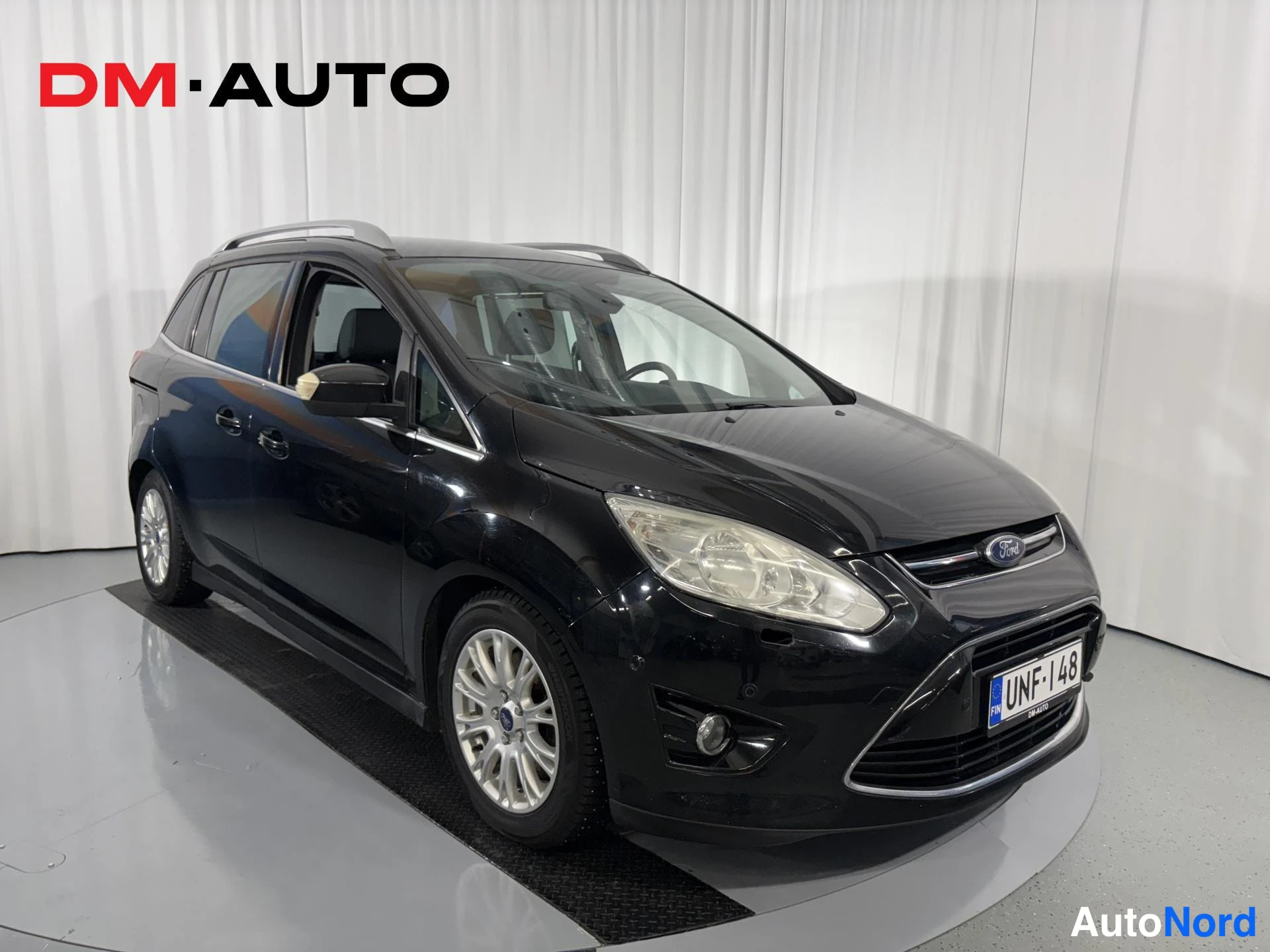 Etuviisto, nokka oikealle: Mustan Ford C-MAX -tilavaunun etukulmakuva, keula ja vasen kylki näkyvissä hopeisilla kevytmetallivanteilla.