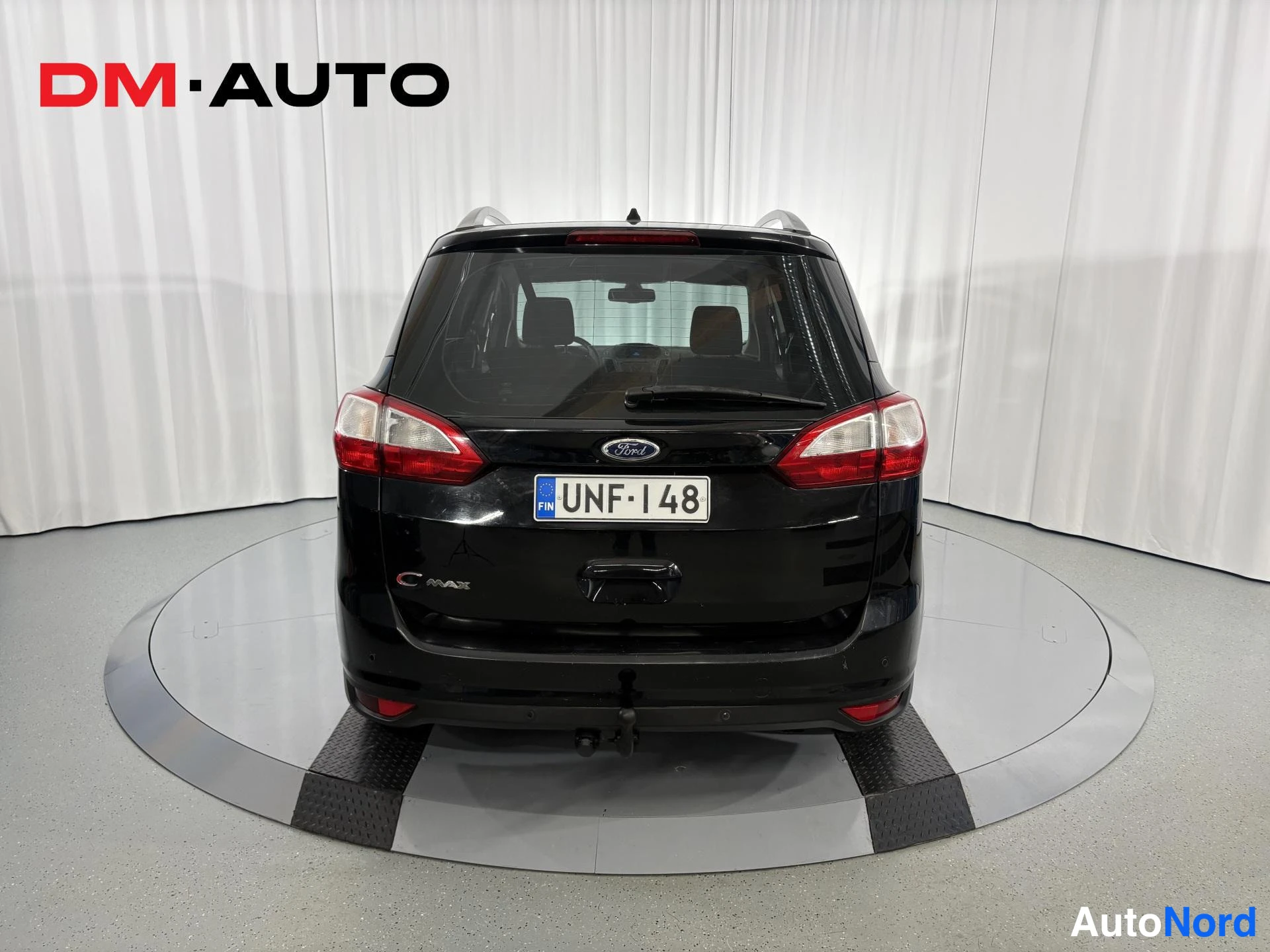Takaa: Mustan Ford C-MAX:n takanäkymä suoraan takaa, takavalot, Ford-merkki ja rekisteritunnus näkyvissä.