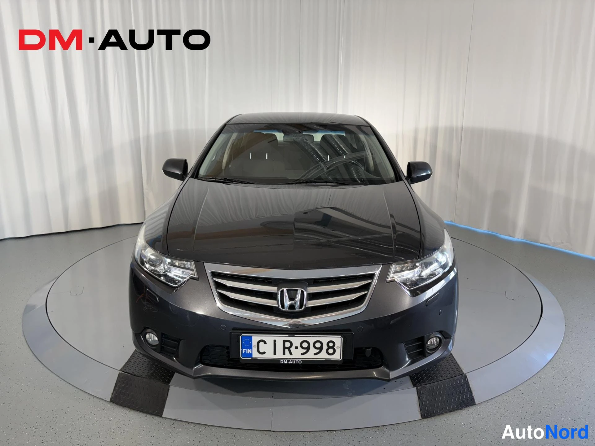 Edestä: Tummanharmaan Honda Accord -sedanin edestäpäin kuva, rekisterikilpi.