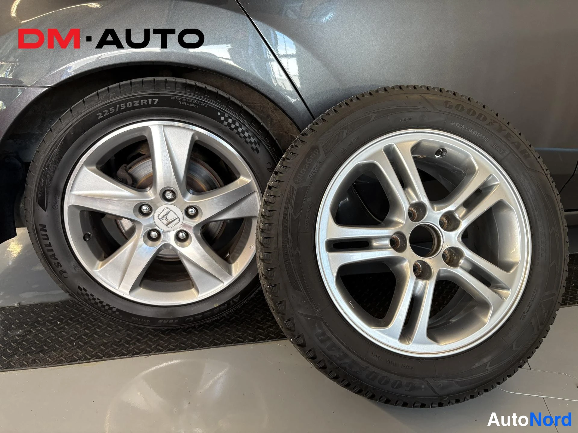 Muu: Kaksi alumiinvannasta esillä: vanne kiinni autossa, 225/50 R17 SAILUN-kesärengas, ja vieressä Goodyear-talvirengas 205/50 R17.