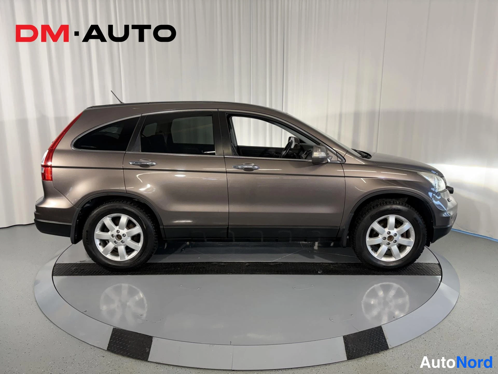 Sivulta: Honda CR-V sivulta oikealta, ruskeaharmaa koripinta, hopeiset vanteet näkyvissä.