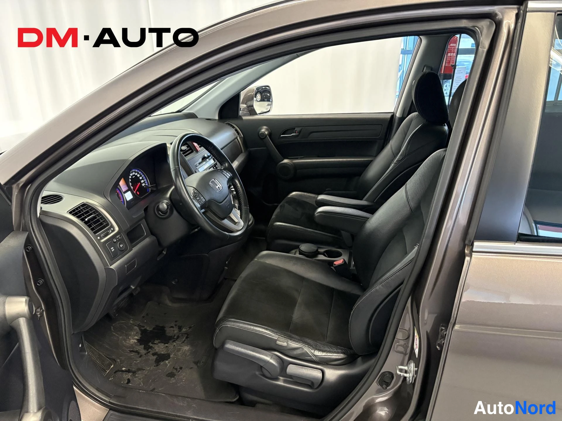 Muu: Avatun etuoven kohdalta kuvattu Honda CR-V:n etuosan sisätilat: tumma ohjaamo, kaksipuolinen ohjaustehostin- ja infotainnauksen painikkein varustettu ohjauspyör