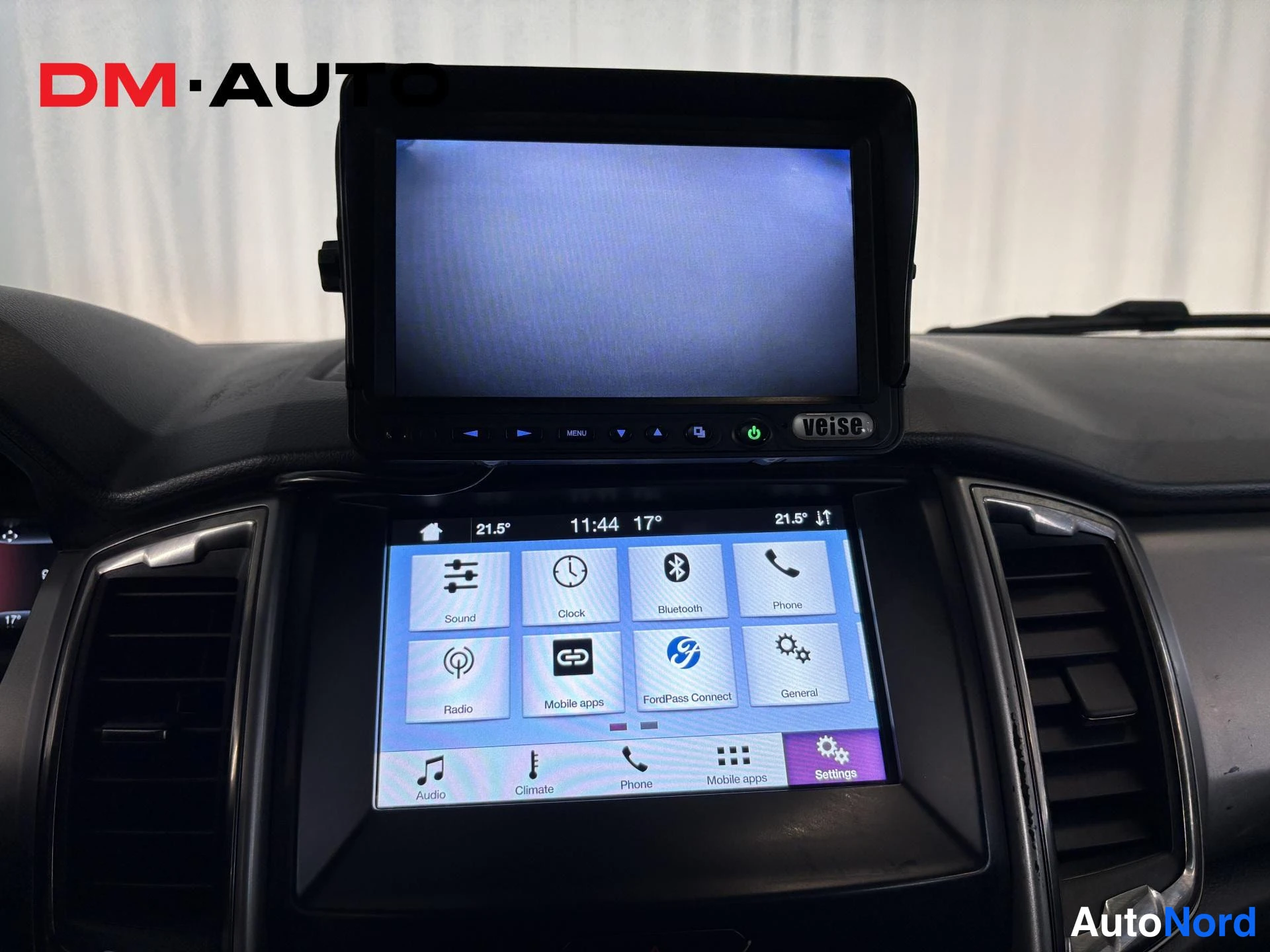 Muu: Kojelaudan infotainment-näyttö valikossa (Sound, Clock, Bluetooth, Phone, Radio, FordPass Connect) ja sen päällä asennettu erillinen Veise-navigointinäyttö.