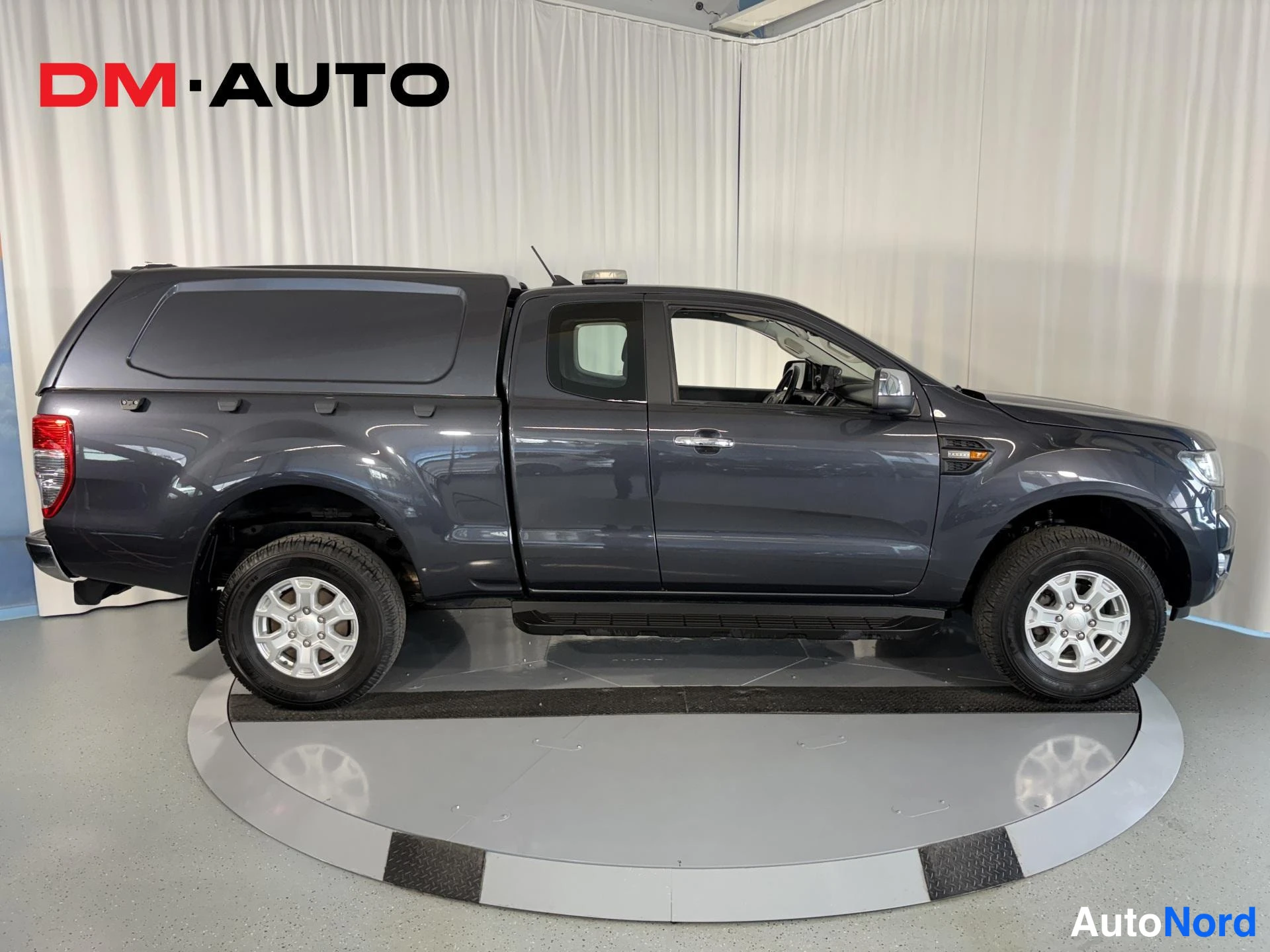 Sivulta: Tummanharmaa Ford Ranger -avaustakavara suoraan sivusta; kylkiossi, peilit ja kromilistat näkyvät.
