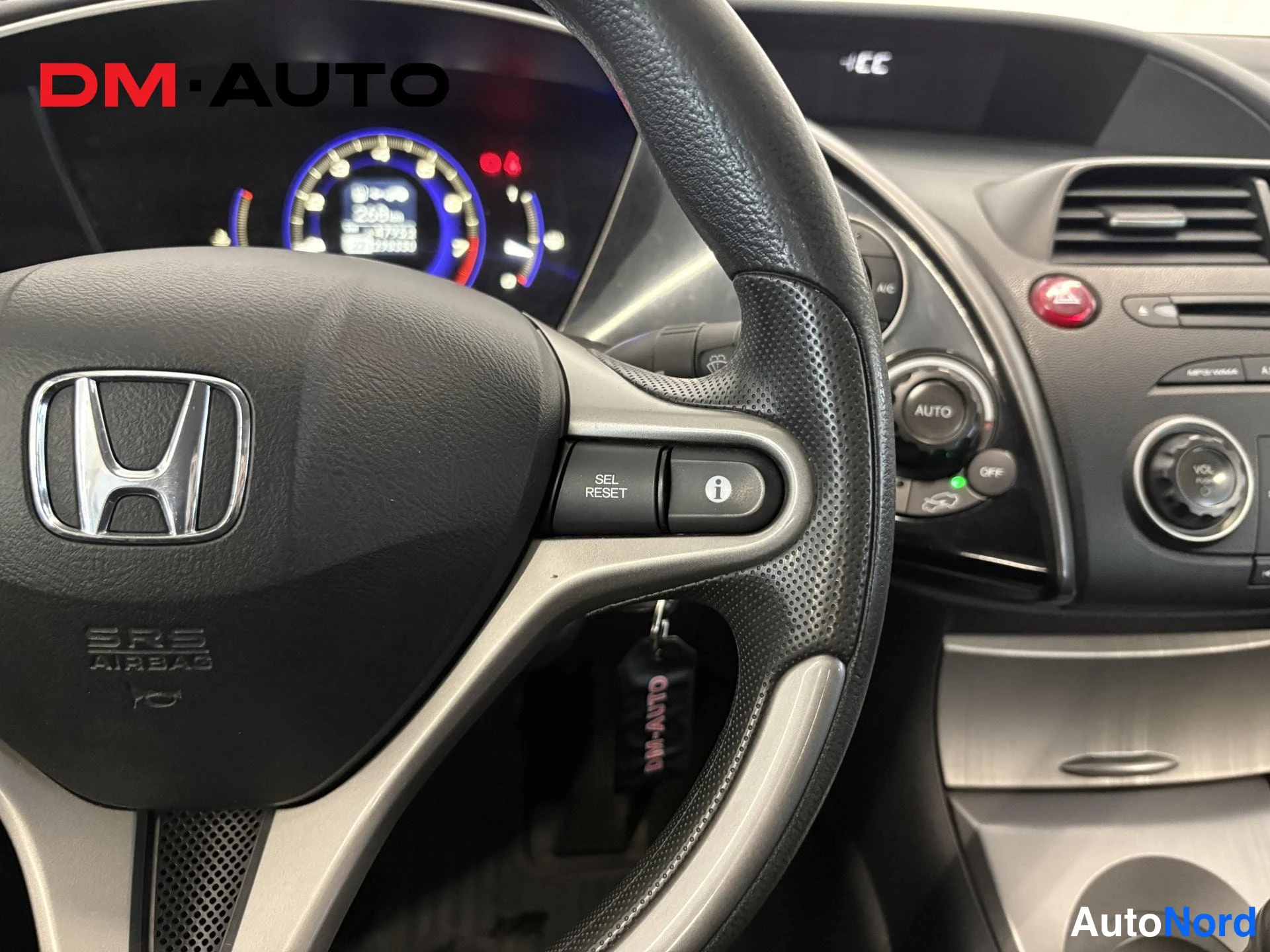 Muu: Ohjauspyörä ja kojelauta: Honda-merkki ohjauspyörässä, SRS AIRBAG-teksti, mittariston näyttö ja 'AUTO'-ilmastointinappi näkyvät.