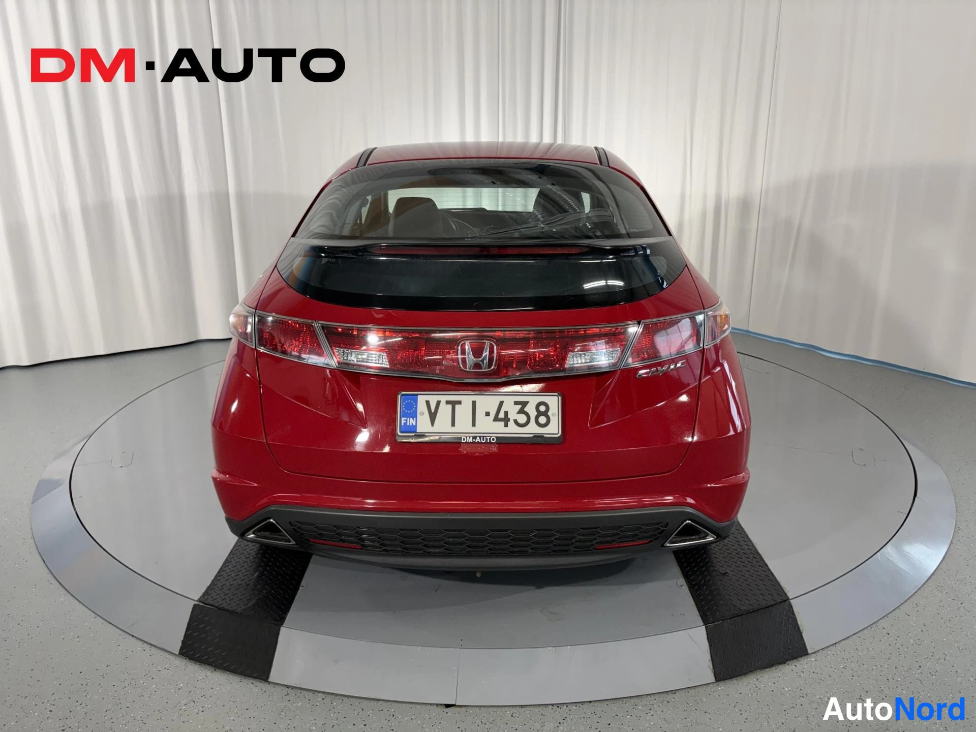 Takaa: Punaisen Honda Civic -viistoperän suora takanäkymä; näkyvät leveät takavalot, Honda-merkki, Civic-teksti, rekisterikilpi VTl·438 ja kaksi pakoputkea.