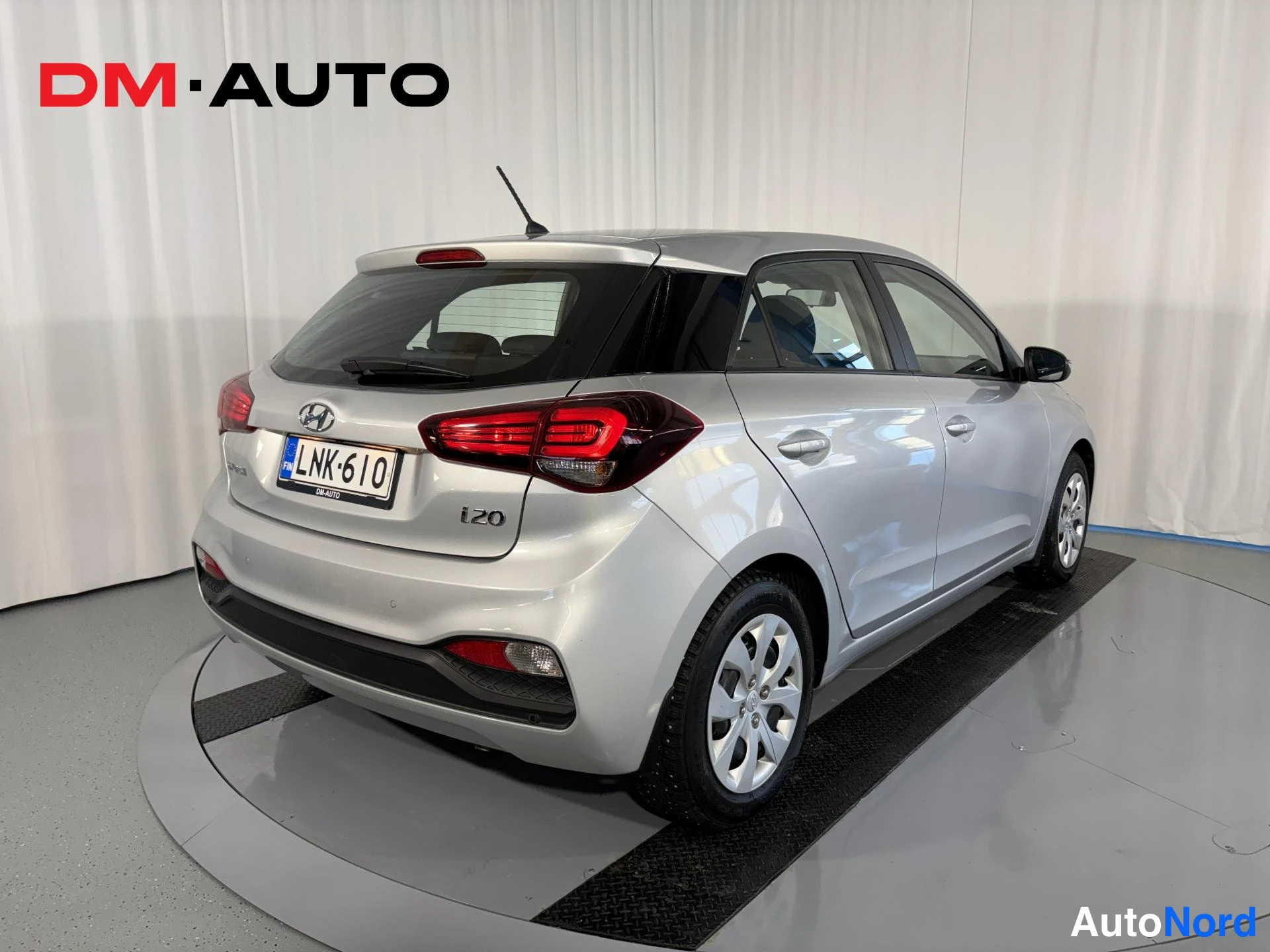 Takaviisto: Hyundai i20 -porssikuva takaa oikealta kulmalta; rekisterikilpi, i20-merkintä takaluukussa ja hopeinen koriväri näkyvät.