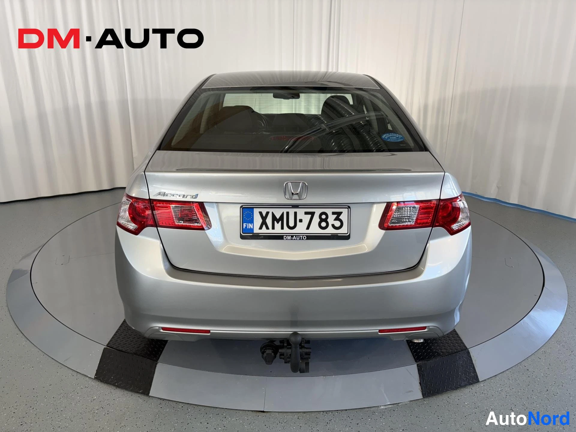 Takaa: Honda Accord -sedan takaosa suoraan takaa; hopeinen kori, punaiset takavalot, honda-merkki ja rekisterikilpi.