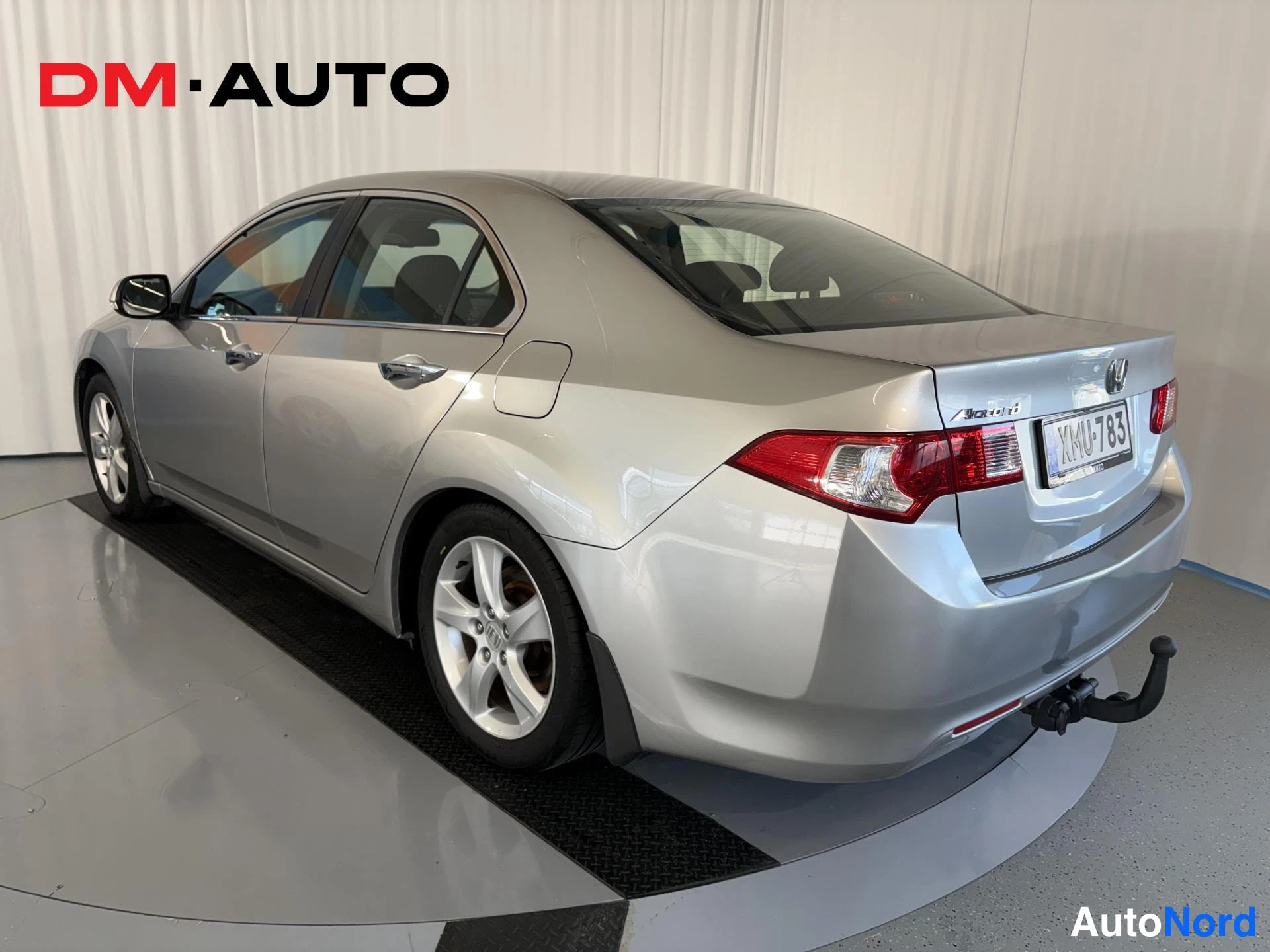 Takaviisto: Honda Accord -sedan takakulma oikealta sivulta; hopeinen kori, punaiset takavalot ja -rekisterikilpi.