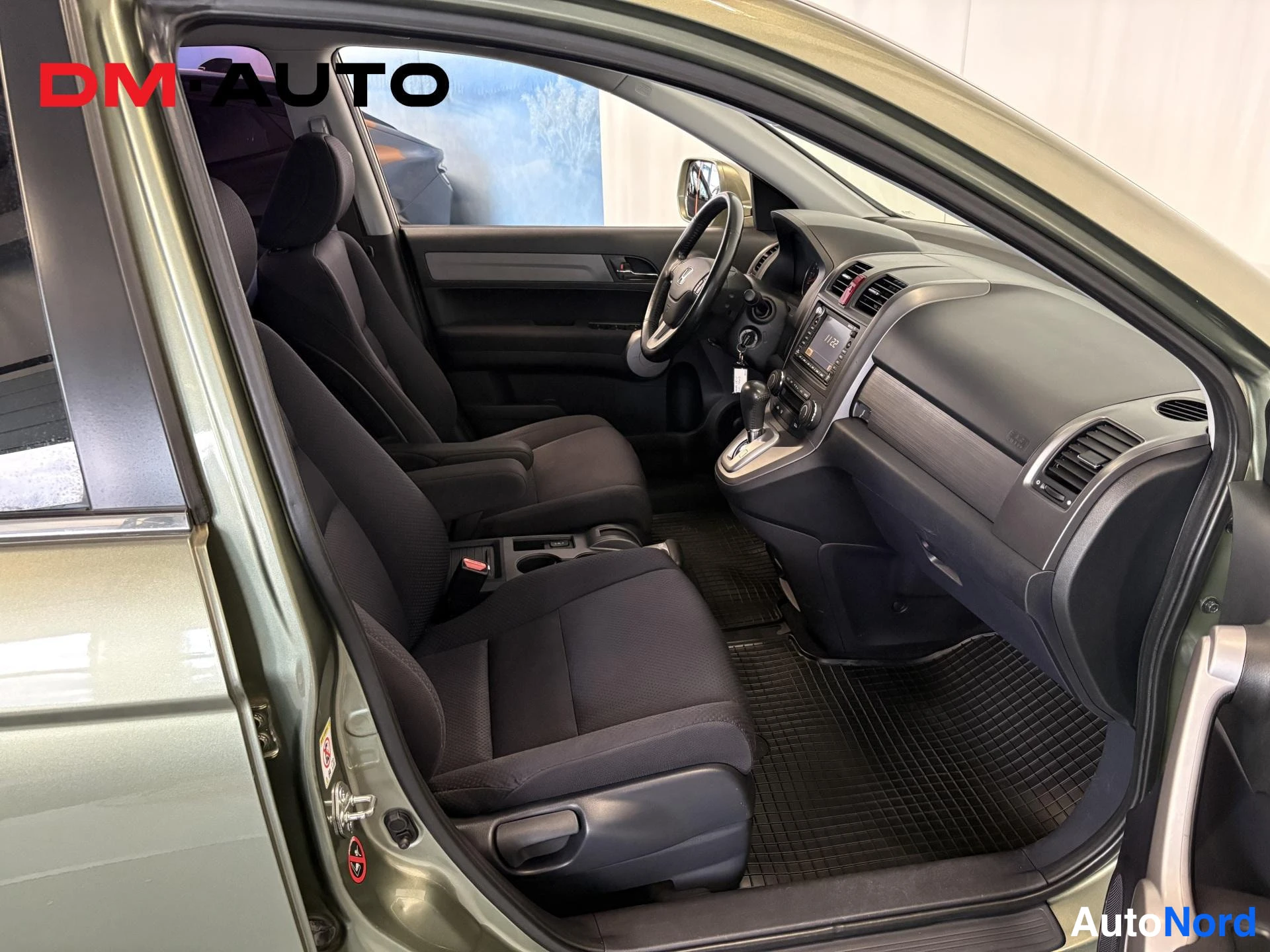 Muu: Honda CR-V:n etupenkit, ohjaamo ja kojelauta ovista kuvattuna; tummat kangasistuimet ja mattolattiat.
