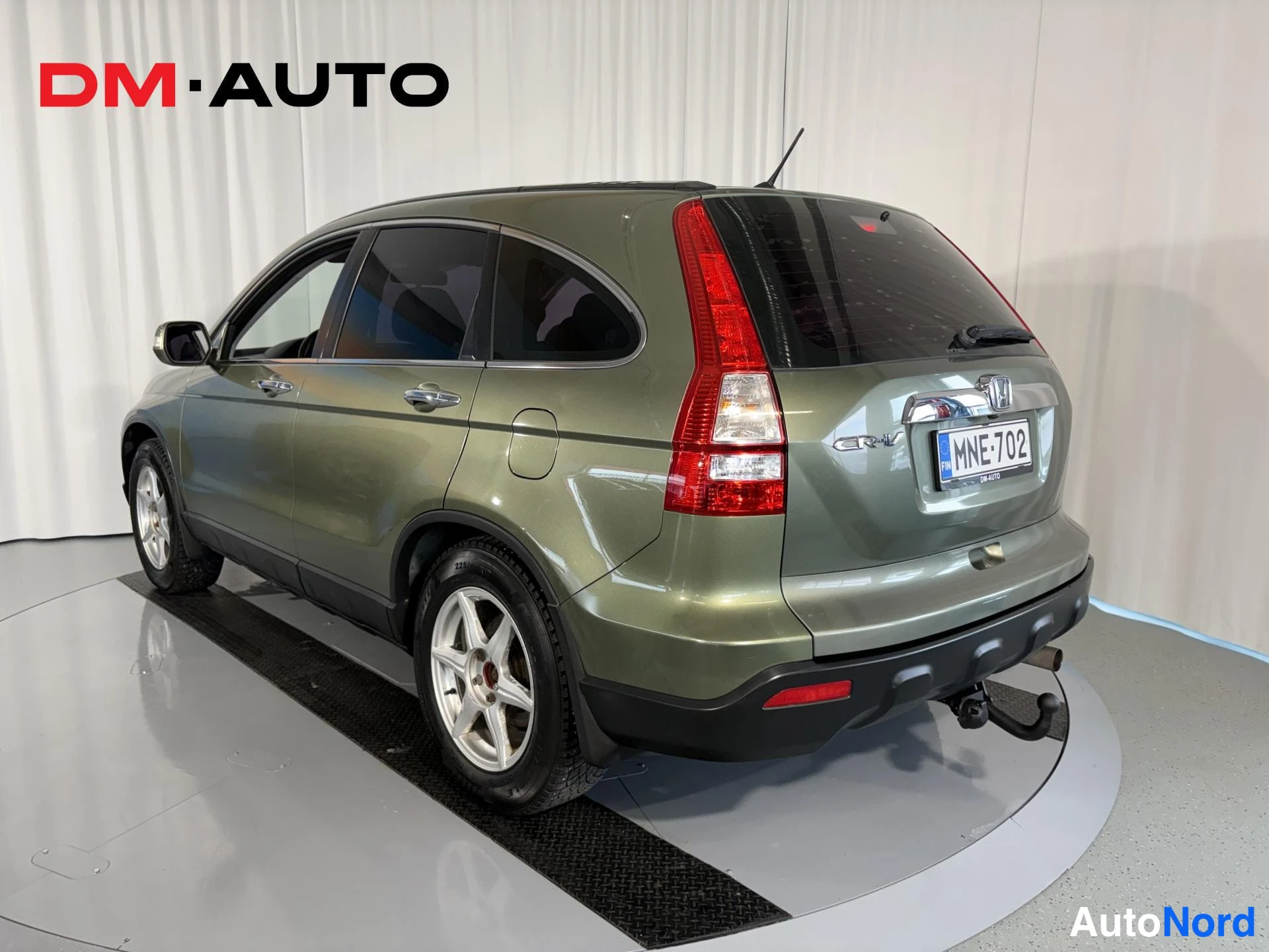 Takaviisto: Honda CR-V takaa viistosti vasemmalta kuvattuna, vihreä koriväri, rekisterikilpi, vetokoulu näkyvissä.