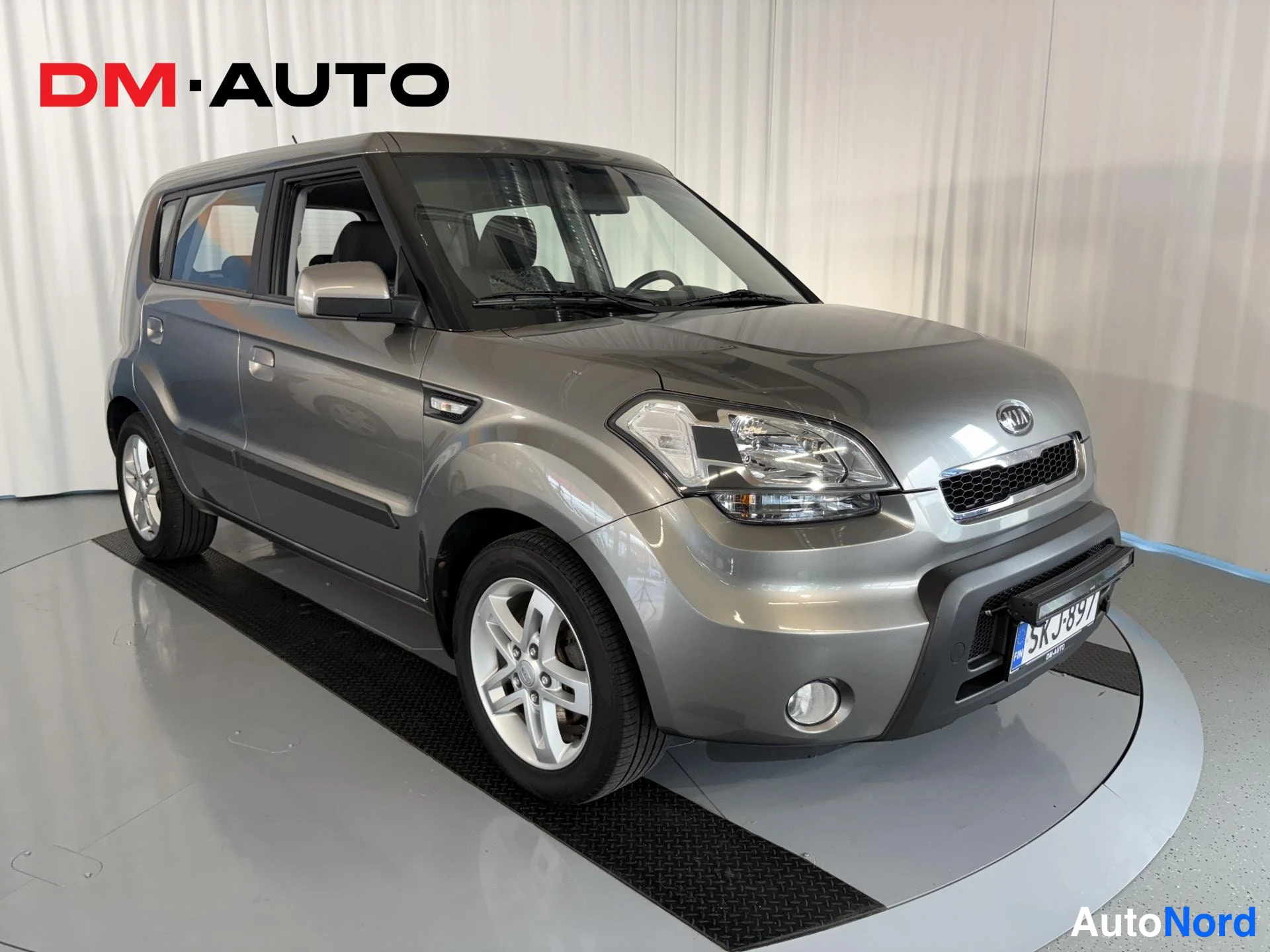 Etuviisto, nokka oikealle: Kia Soul harmaana etuviistosta oikealta, rekisterikilpi.