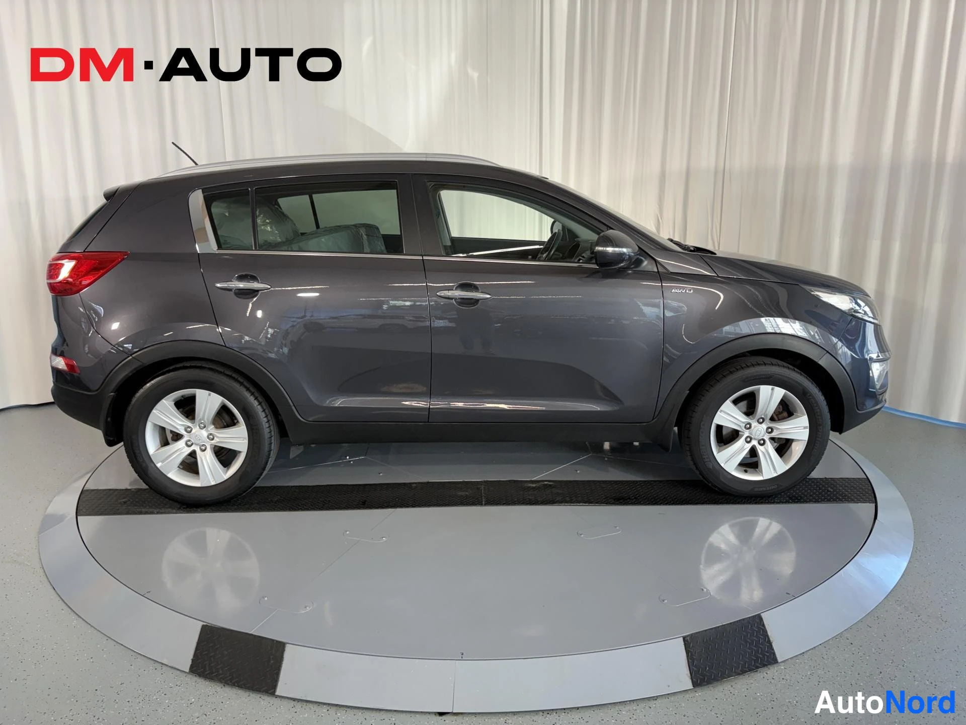 Sivulta: Kia Sportage - farmari, sivukuva vasemmalta, tummanharmaa kori, viisiovinen korirakenne.