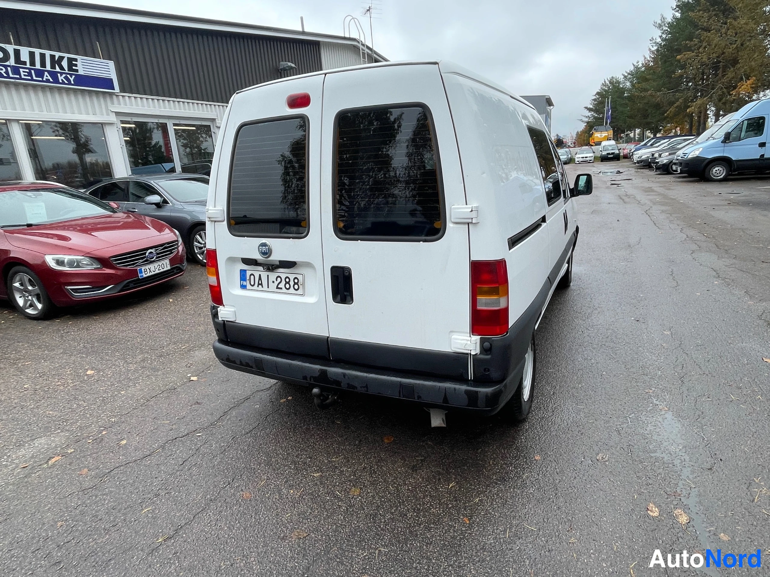 Takaviisto: Valkoisen pakettiauton takaosa ja右 kylki takaa kuvattuna, rekisteritunnus.