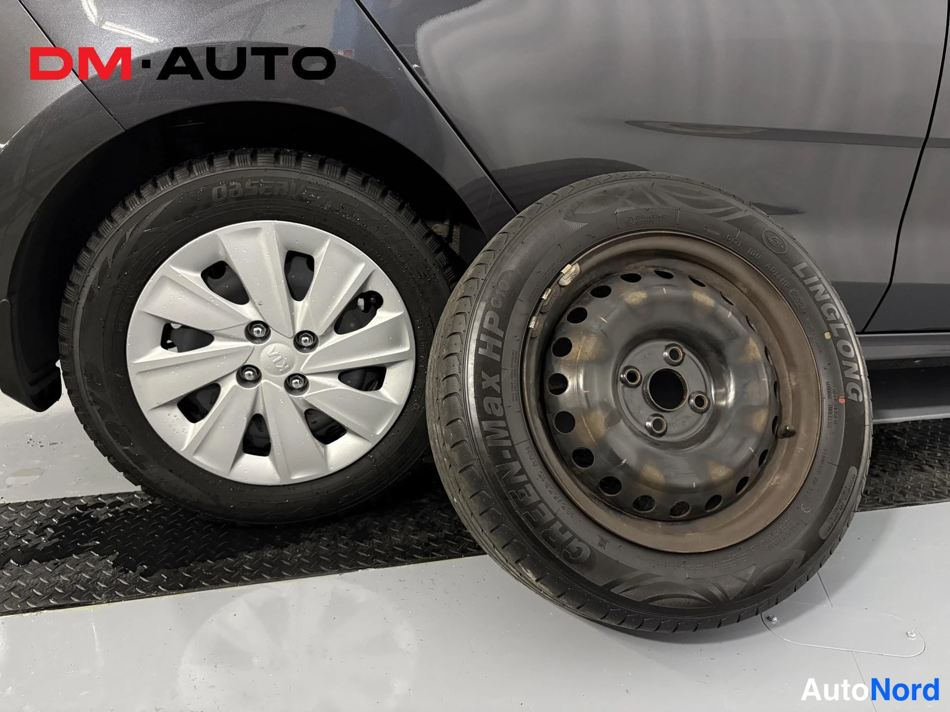Sivulta: Auton pyörä näkyy vanteellaan ja sen vieressä irtonainen varapyörä teräsvanteella; renkaassa lukee Linglong Green-Max HP.