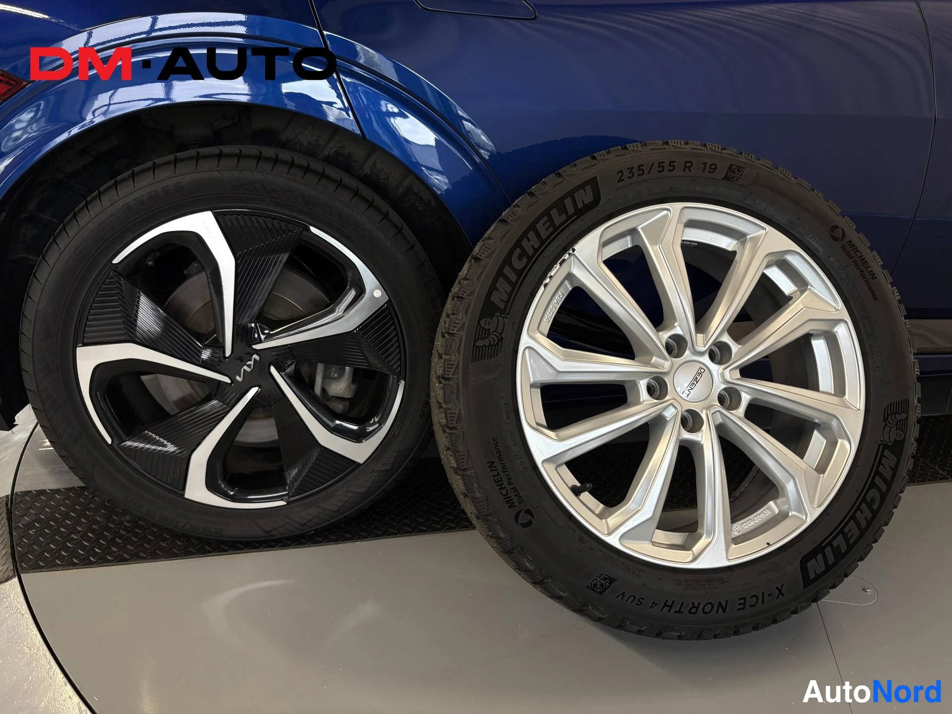 Sivulta: Recall nostettu lähikuva auton pyörästä ja samankokoisesta talvirenkavanteesta; Michelin X-Ice North 4 SUV 235/55 R 19 -rengas hopeavannetta vasten.