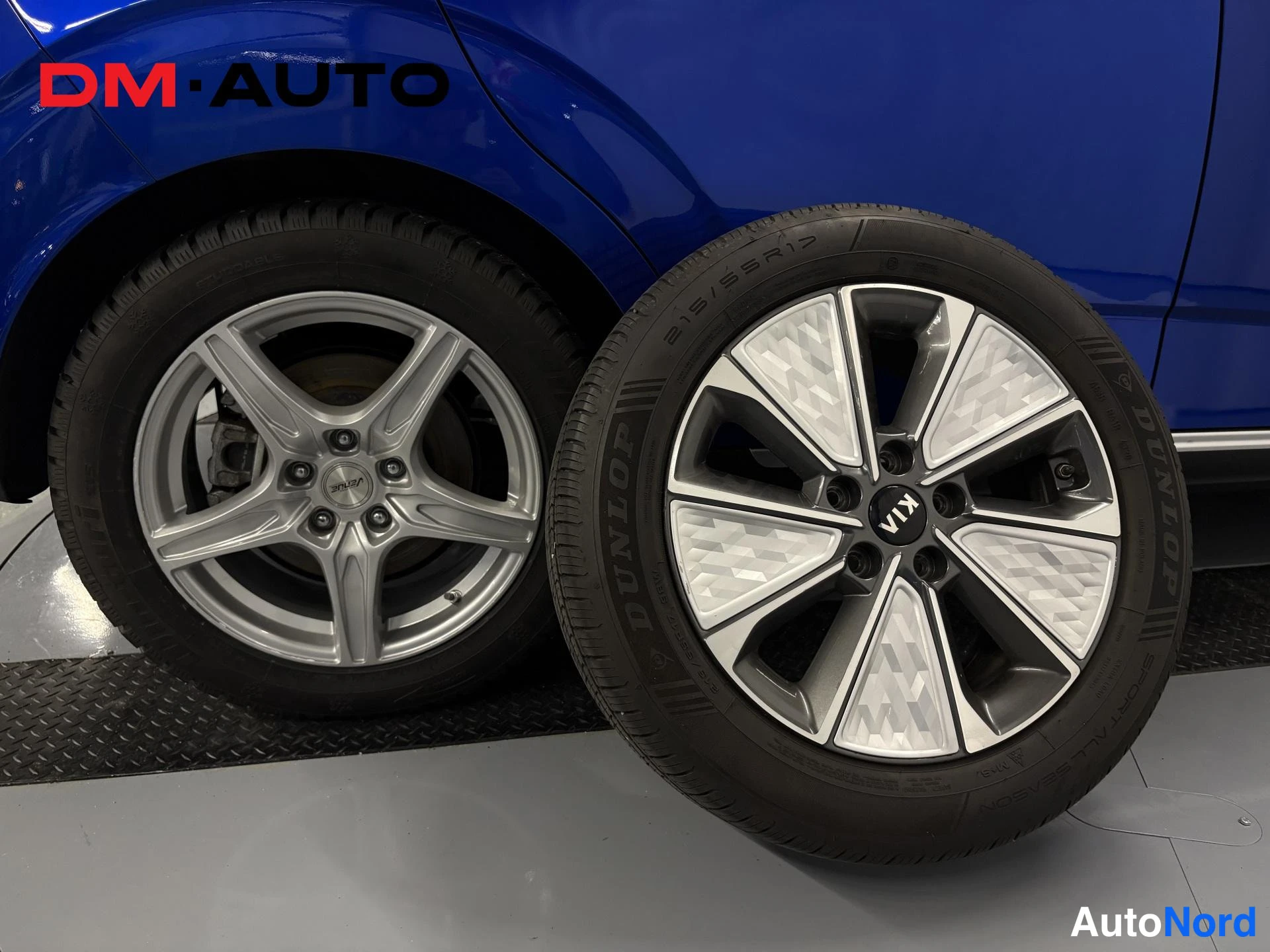 Yksityiskohta: Kuvassa auton takapyörä alumiinivanteella sekä irtonainen Dunlop-kesärengas KIA-merkkisellä vanteella.