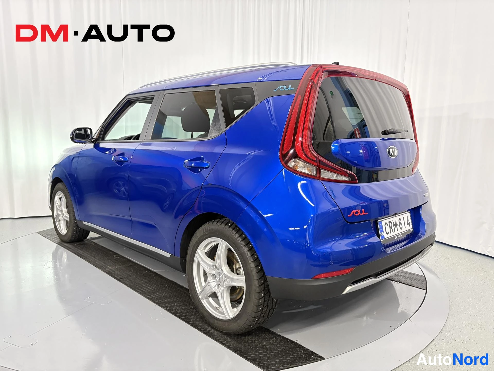 Takaviisto: Sininen Kia e-Soul takaa viistosti oikealta kuvattuna, takavalot ja rekisterikilpi näkyvissä.