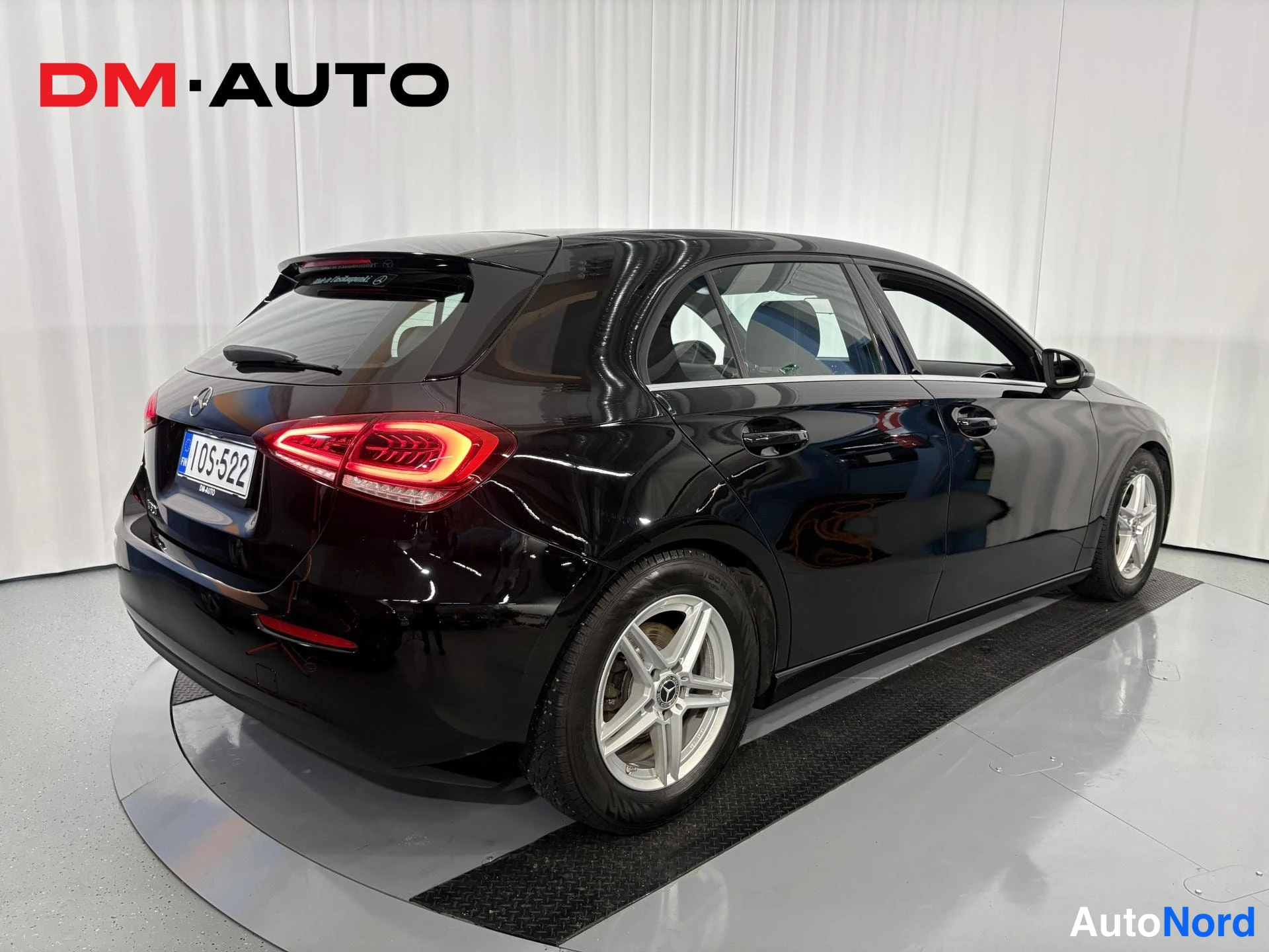 Takaviisto: Mustan Mercedes-Benz A-luokan farmarikorisen auton takakulma vasemmalta kuvattuna; rekisterikilpi.