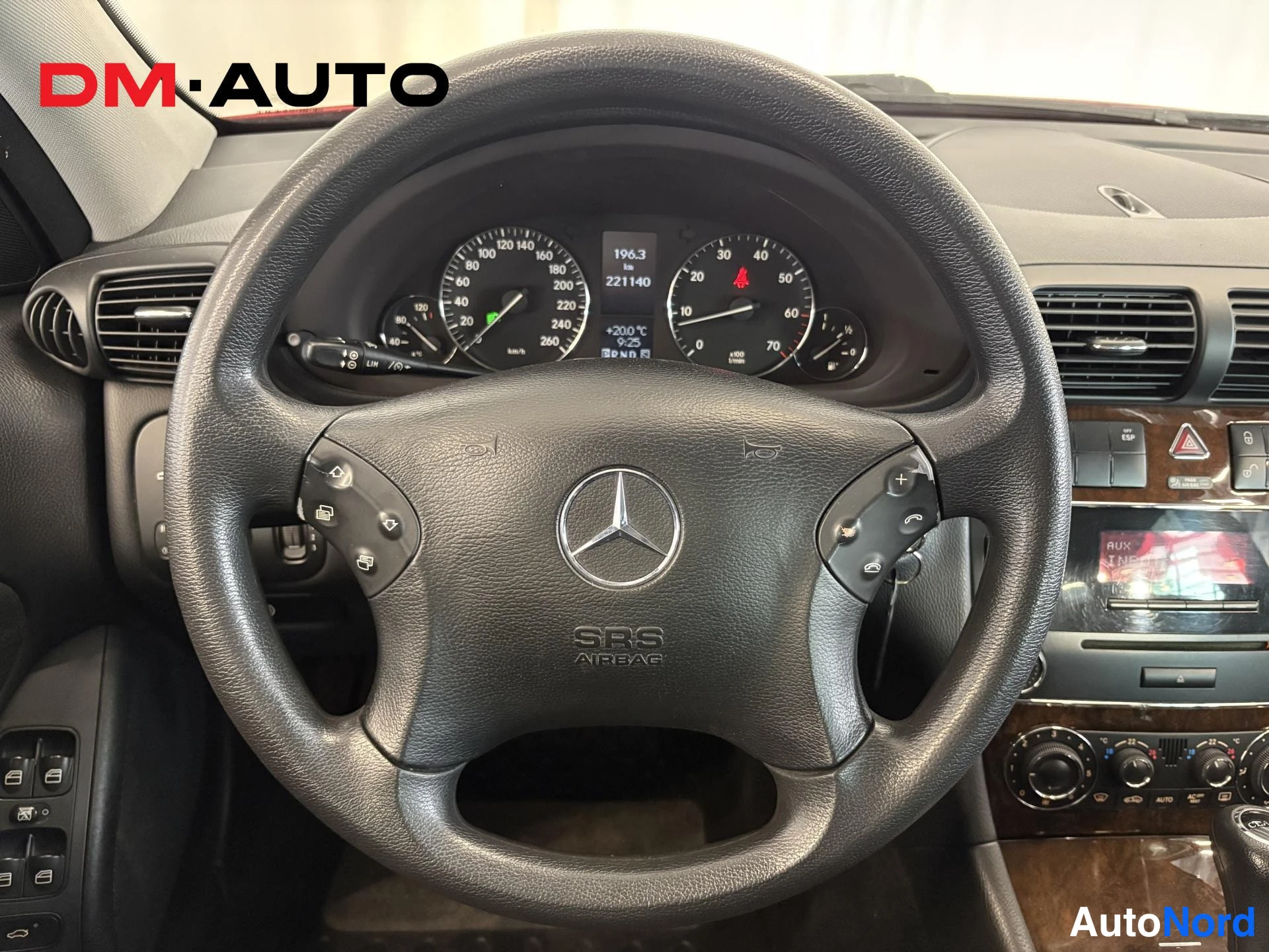 Muu: Lähikuva Mercedes-ohjauspyörästä ja mittaristosta; SRS AIRbag-teksti ohjauspyörässä, näytöllä lukemat 196.3 km ja 221140.