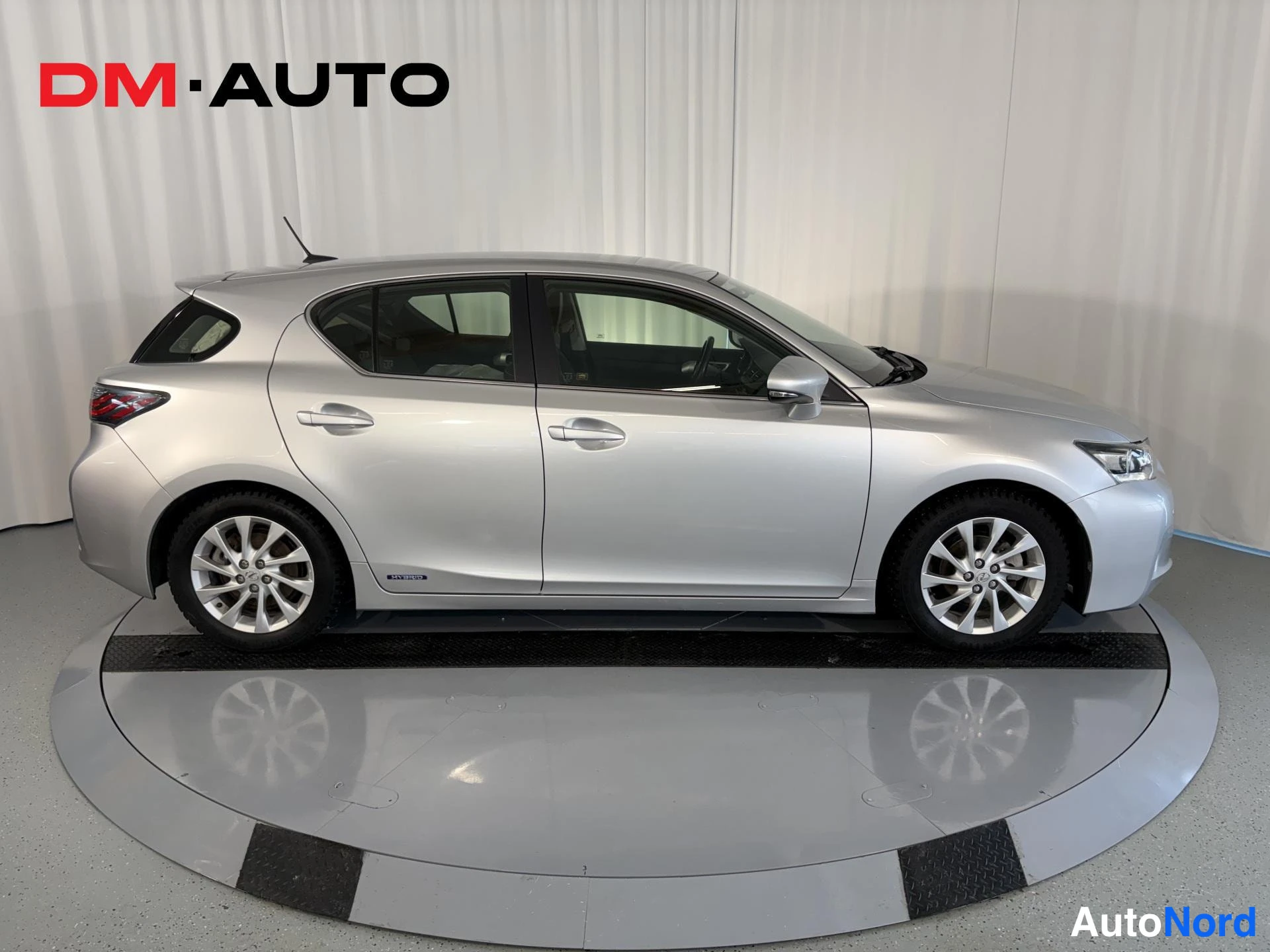 Sivulta: Hopeanvärinen Lexus CT -viistoperä sivulta kuvattuna kääntölavalla.