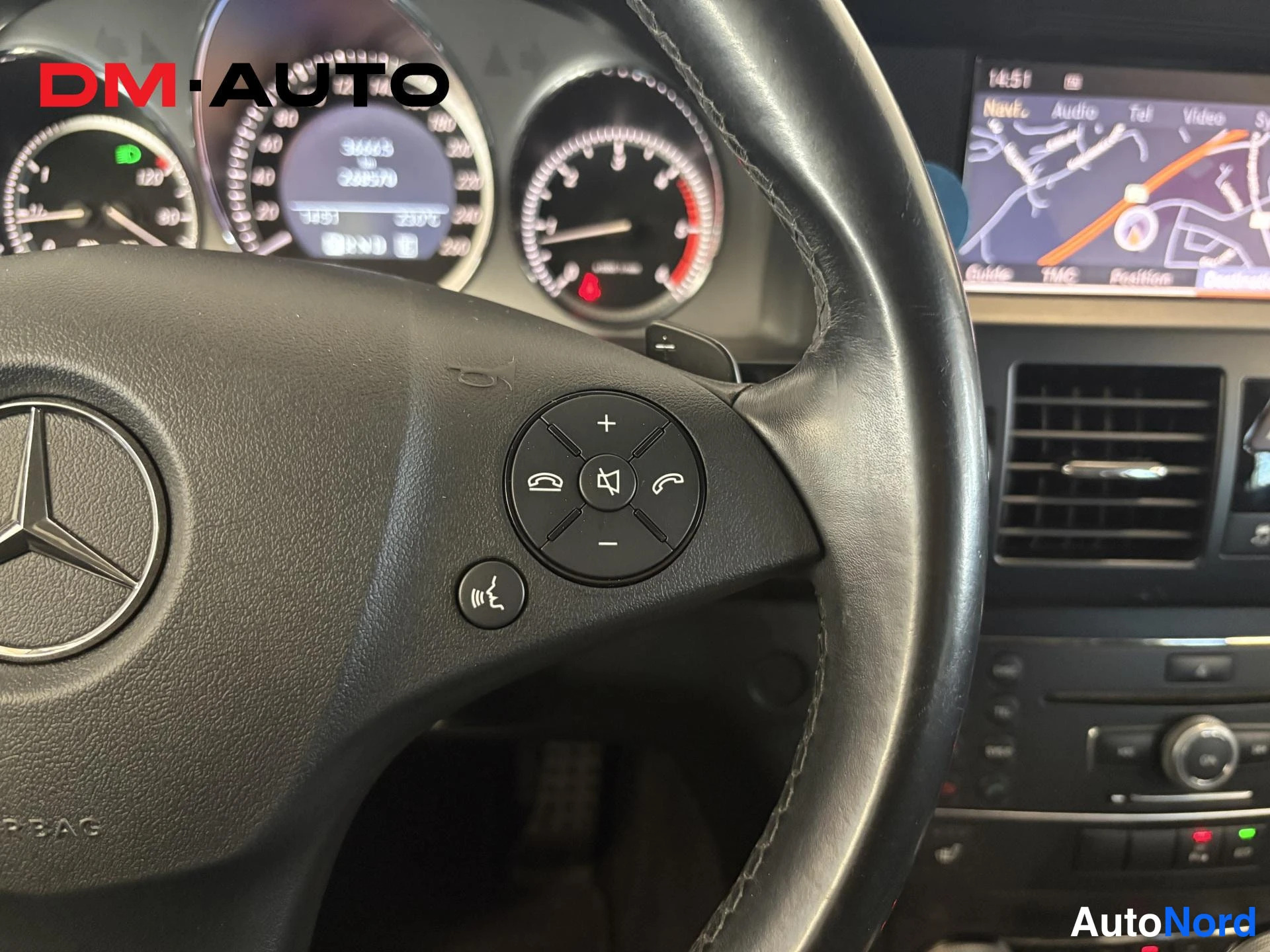 Muu: Ohjauspyörä ja mittaristo Mercedes-Benzissä; näytöllä näkyy lukema 36653 km ja navigointiruutu.