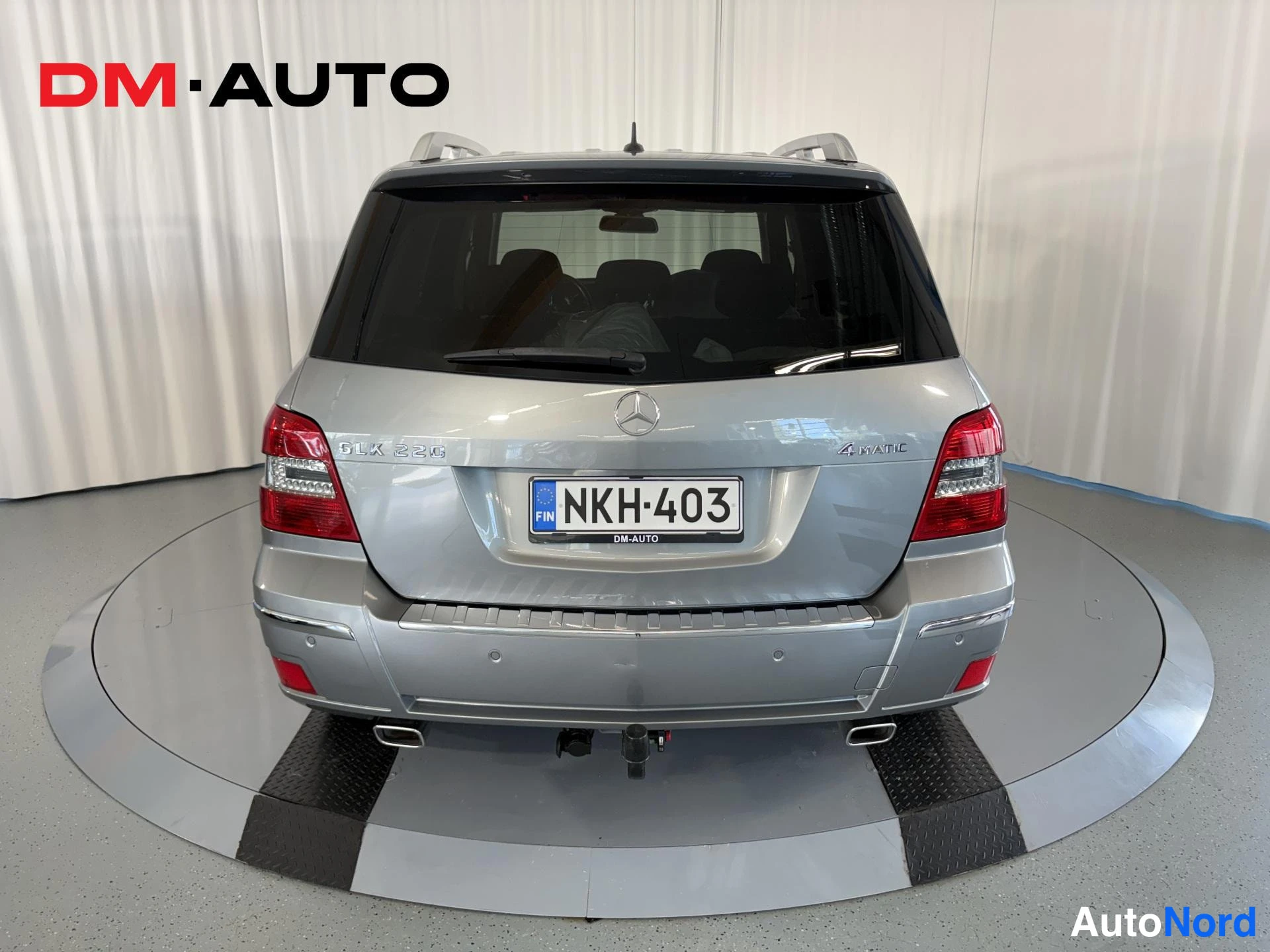 Takaa: Hopeanharmaa Mercedes-Benz GLK suoraan takaa kuvattuna, rekisteritunnus, vetokoukku näkyvissä.