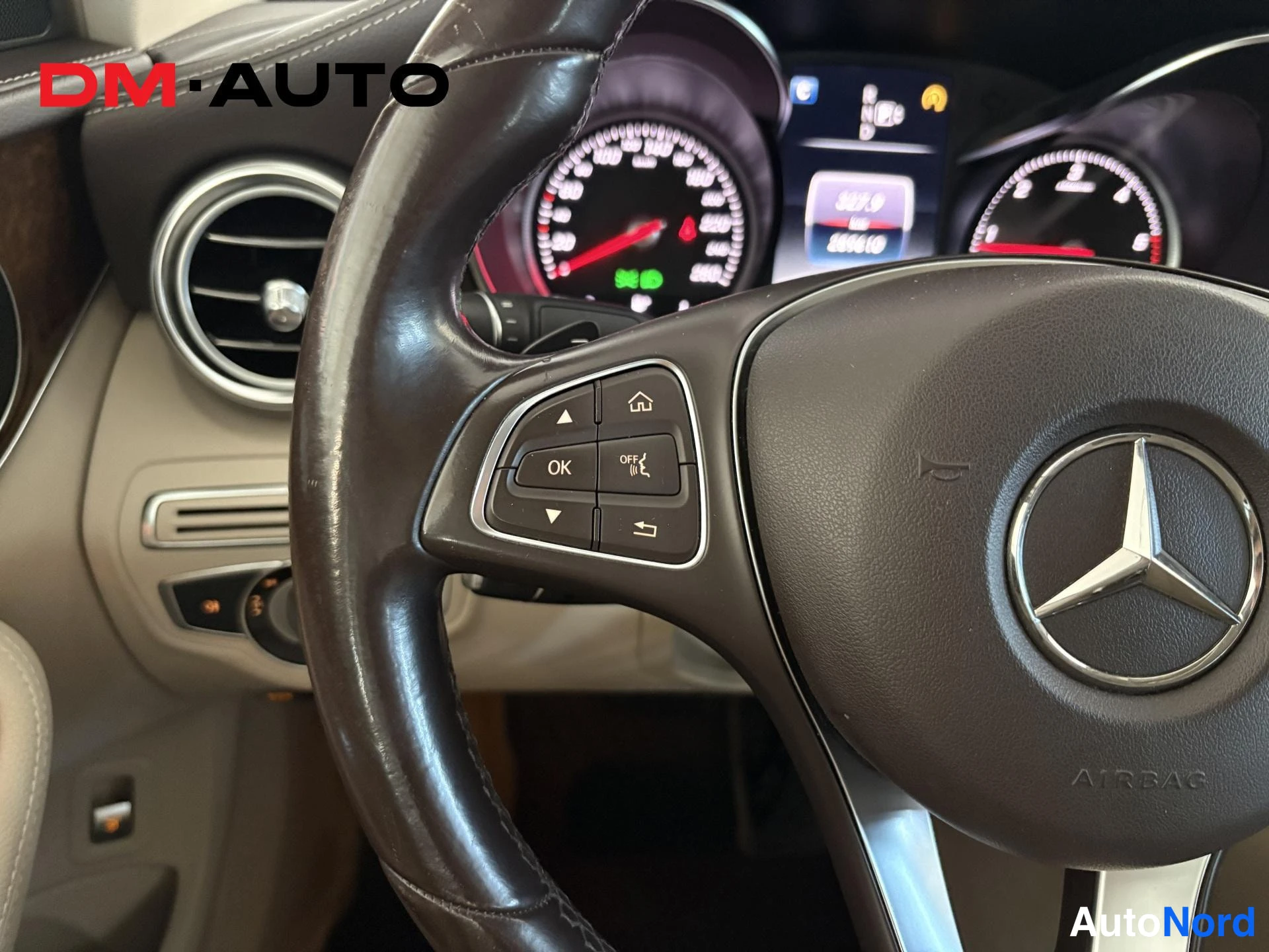 Muu: Mercedes-Benz-ohjauspyörän lähikuva, AIRBAG-merkintä ja monitoimipainikkeet, mittaristolla lukemat 327,9 ja 2990,10.