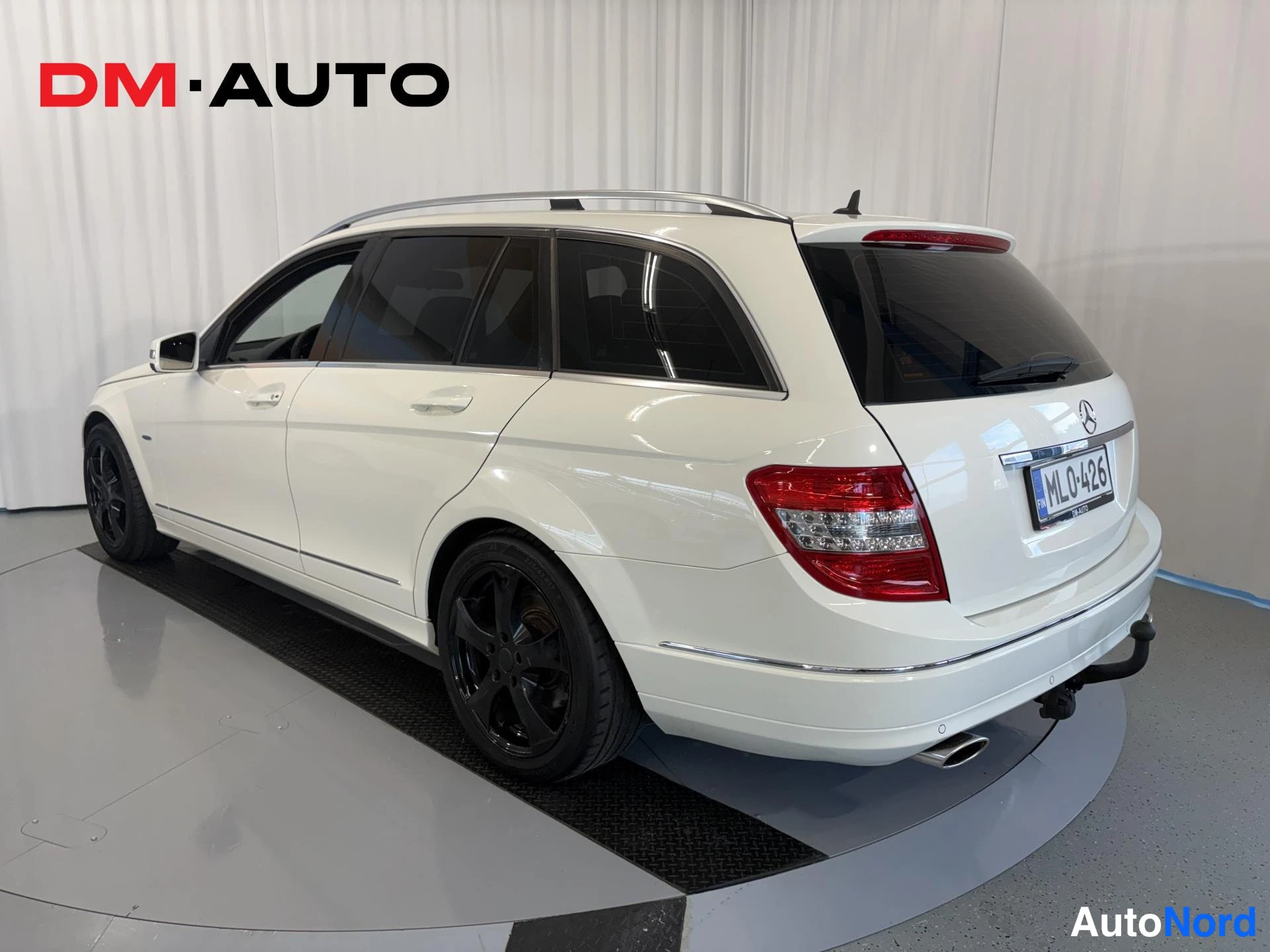 Takaviisto: Mercedes-Benz C-sarjan farmaritakin takaa viistosti vasemmalta, mustat vanteet ja tavaratilan poikittain.