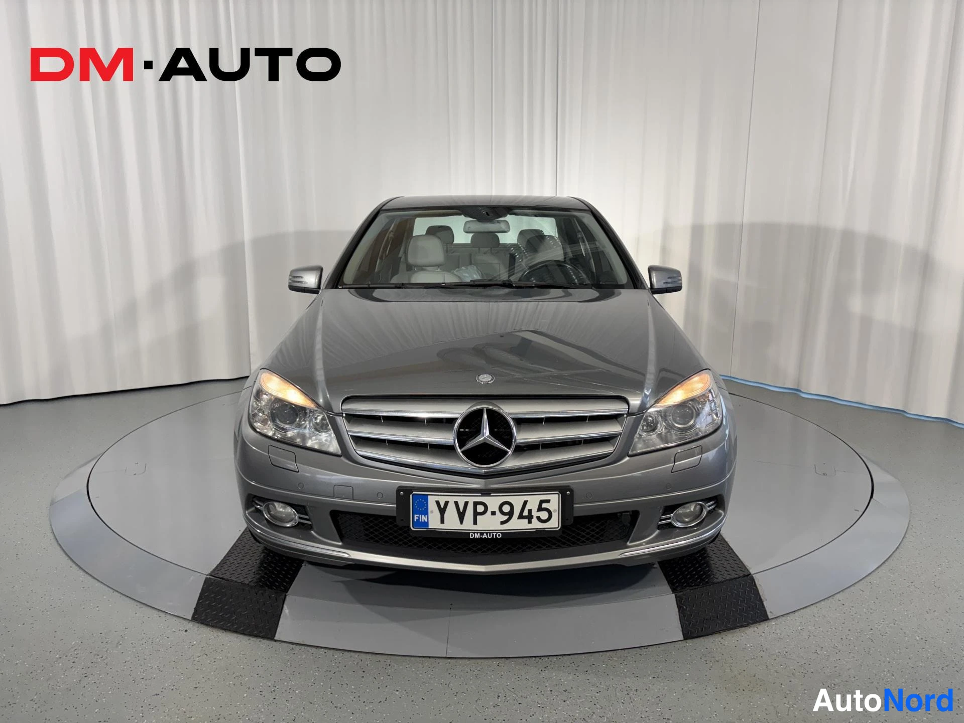 Edestä: Mercedes-Benz C-sarjan sedan edestäpäin, keulan etugrilli ja molemmat ajovalot näkyvät.