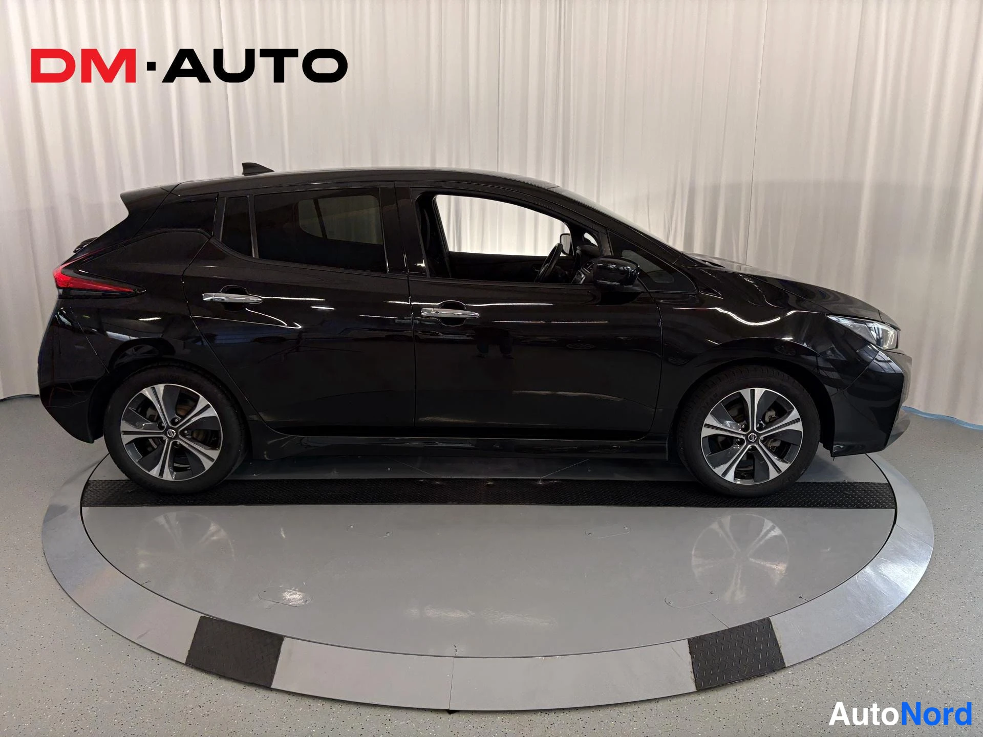 Sivulta: Mustan Nissan Leafin sivuprofiili oikealta, viisiovinen hatchback.