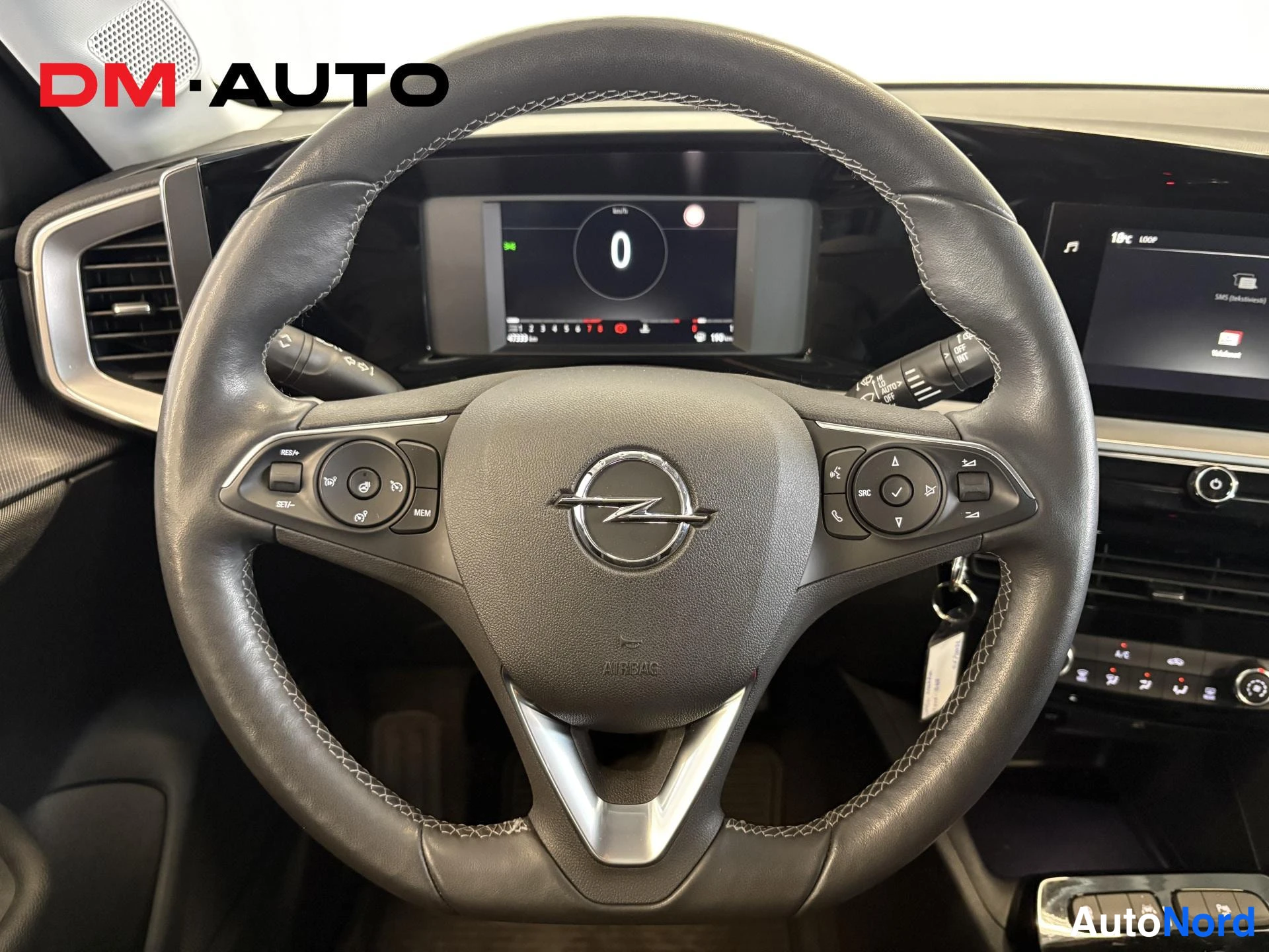 Edestä: Ohjauspyörä Opel-merkillä, monitoiminapit ja mittariston näyttö näkyvissä.